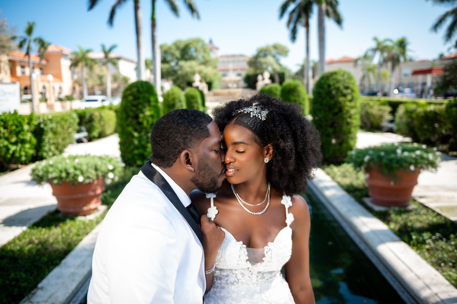 The groom kisses his bride near Worth Avenue in Palm Beach, captured by South Florida wedding photographers.