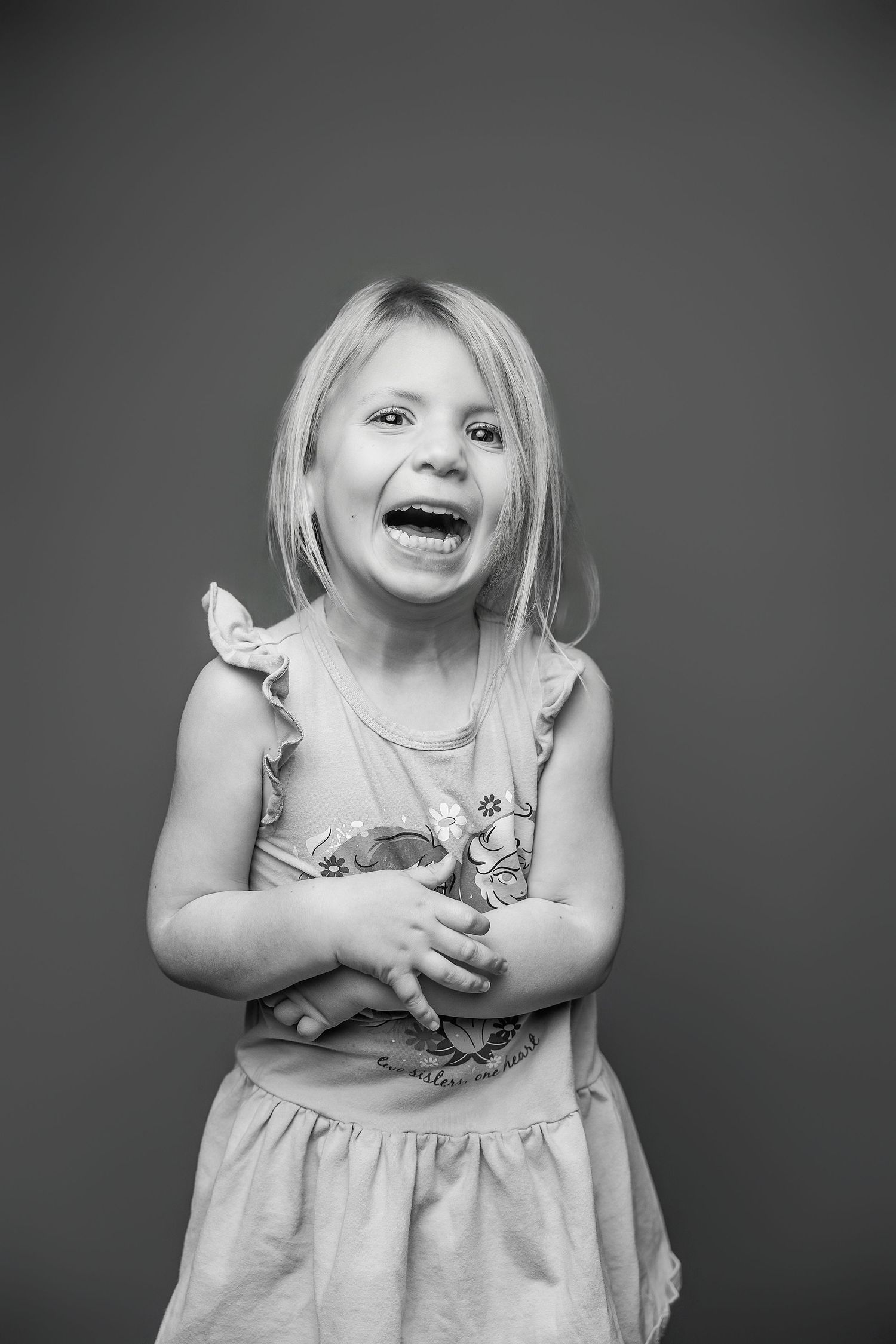A series of black and white photos showing playful expressions and gestures against a dark background.