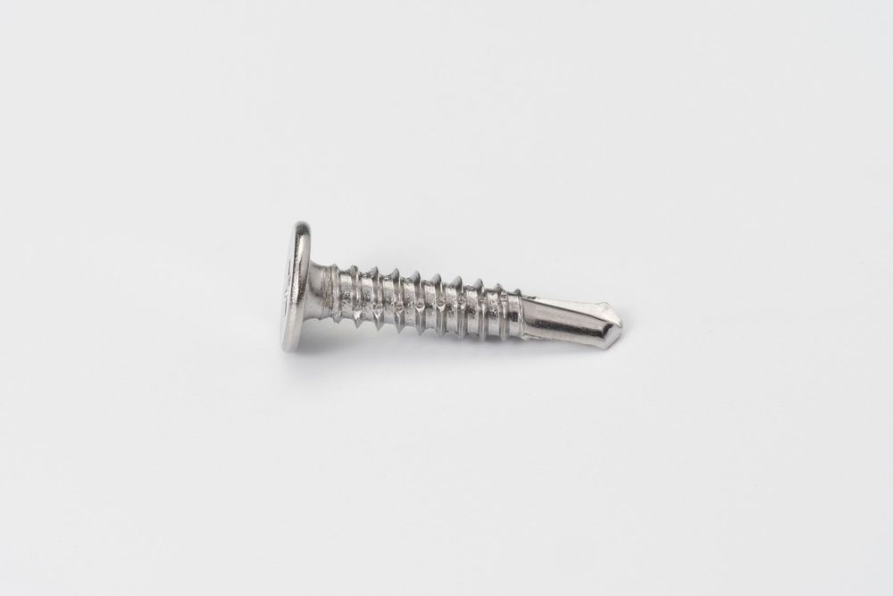 Silver metal spring and coiled wire parts displayed on a white surface with reflective lighting.