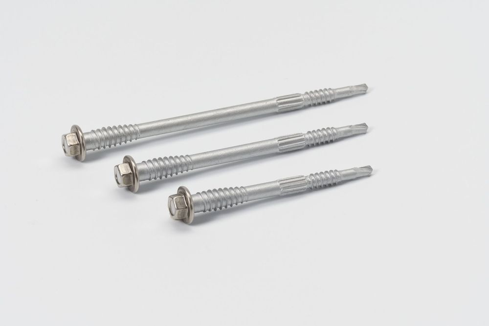 Four silver metal screws of increasing length arranged in a row against a white background.