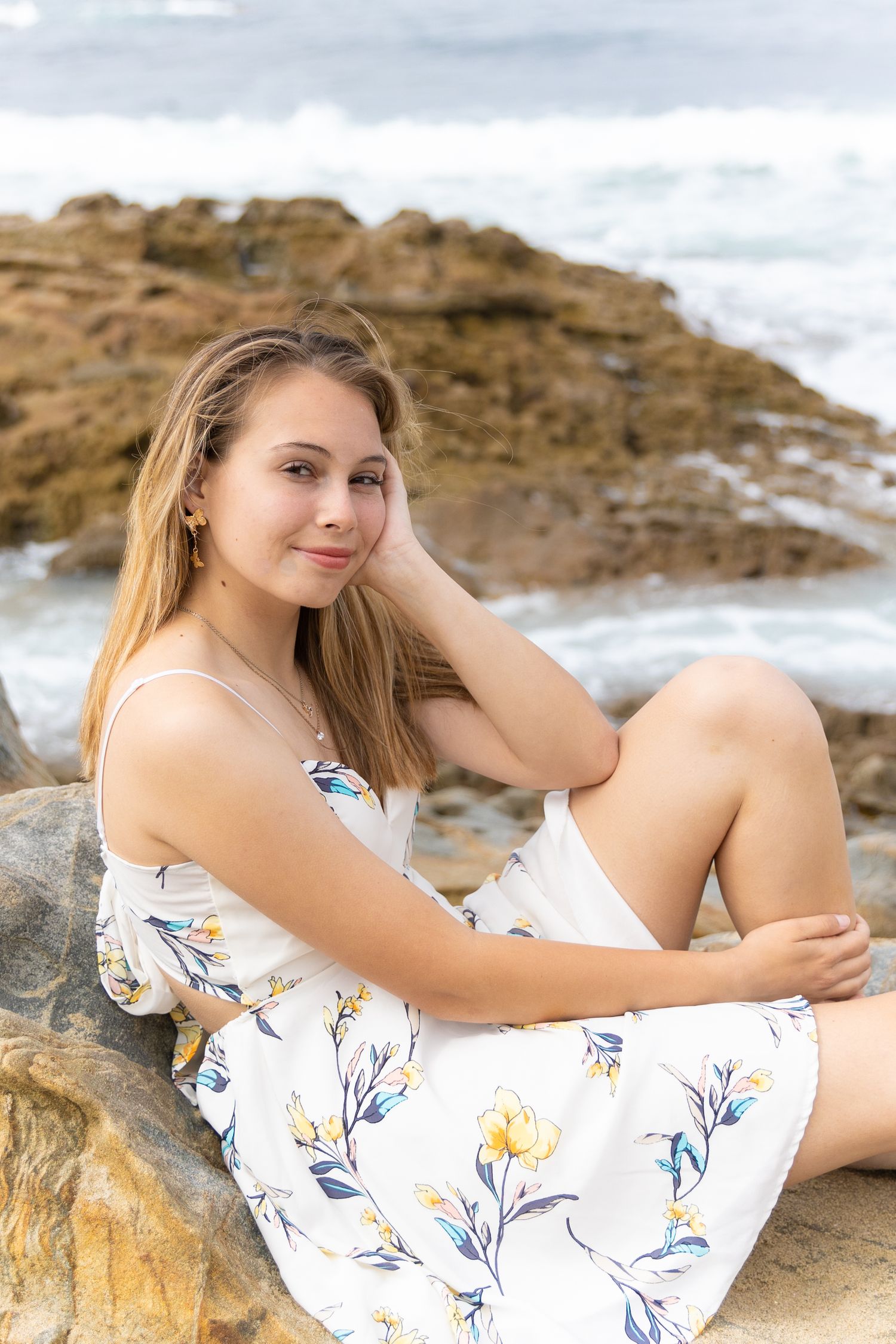 Girl sitting on a rock at the beach in La Jolla