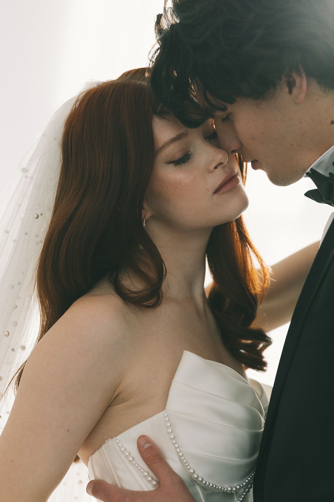 A couple poses together in formal attire, with the woman wearing an elegant white lace dress.
Braut elegant Chiemgau Salzburg