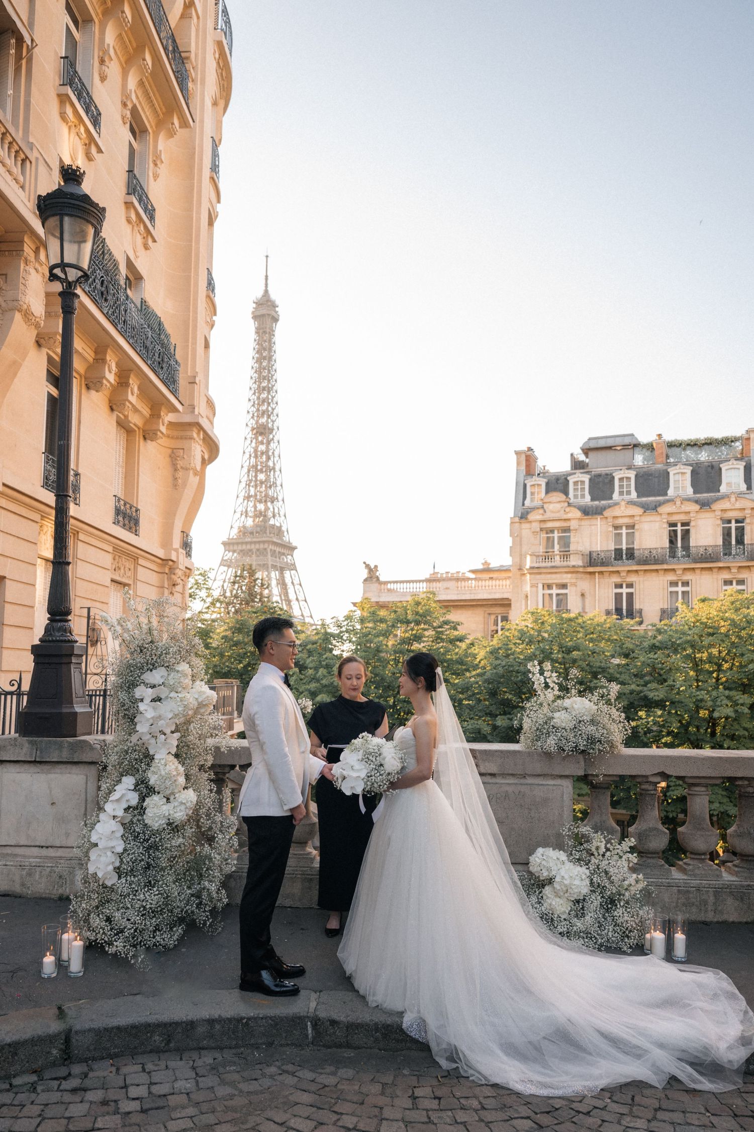 A romantic wedding photoshoot in Paris with the iconic Eiffel Tower visible in the background among classic architecture.