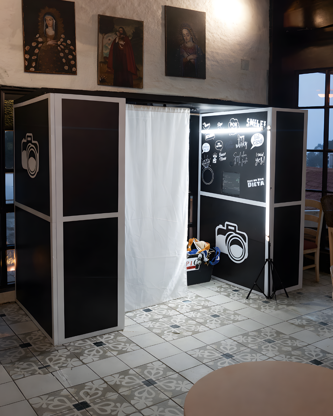 Black and white photo studio setup with lighting equipment and white backdrop visible in a dark room.
