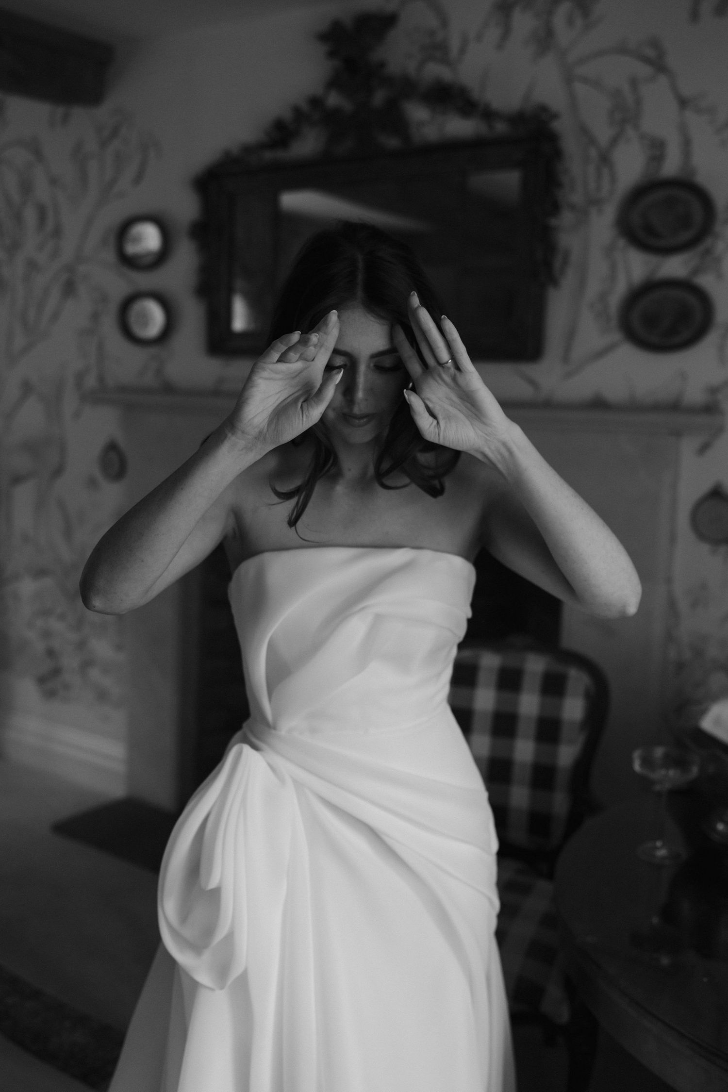 bride brushing hair off face in a quiet moment before the wedding ceremony at dewsall court in herefordshire