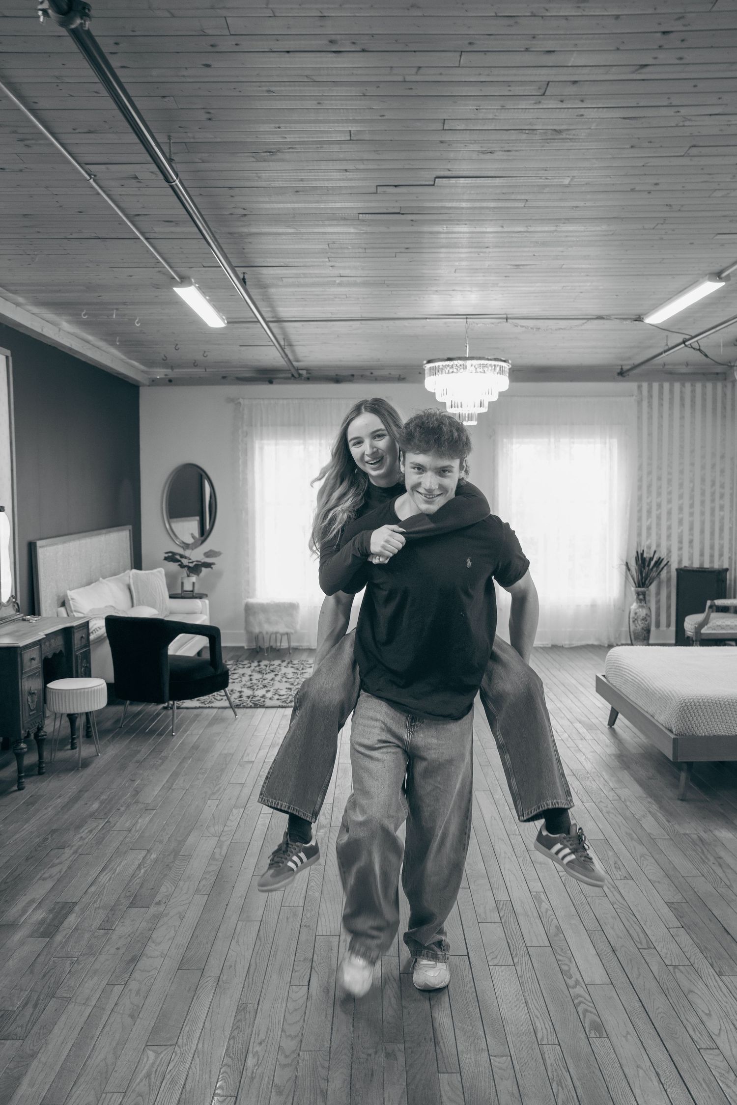 A sequence of black and white photos showing playful movement and interaction on a hardwood floor in an indoor space.