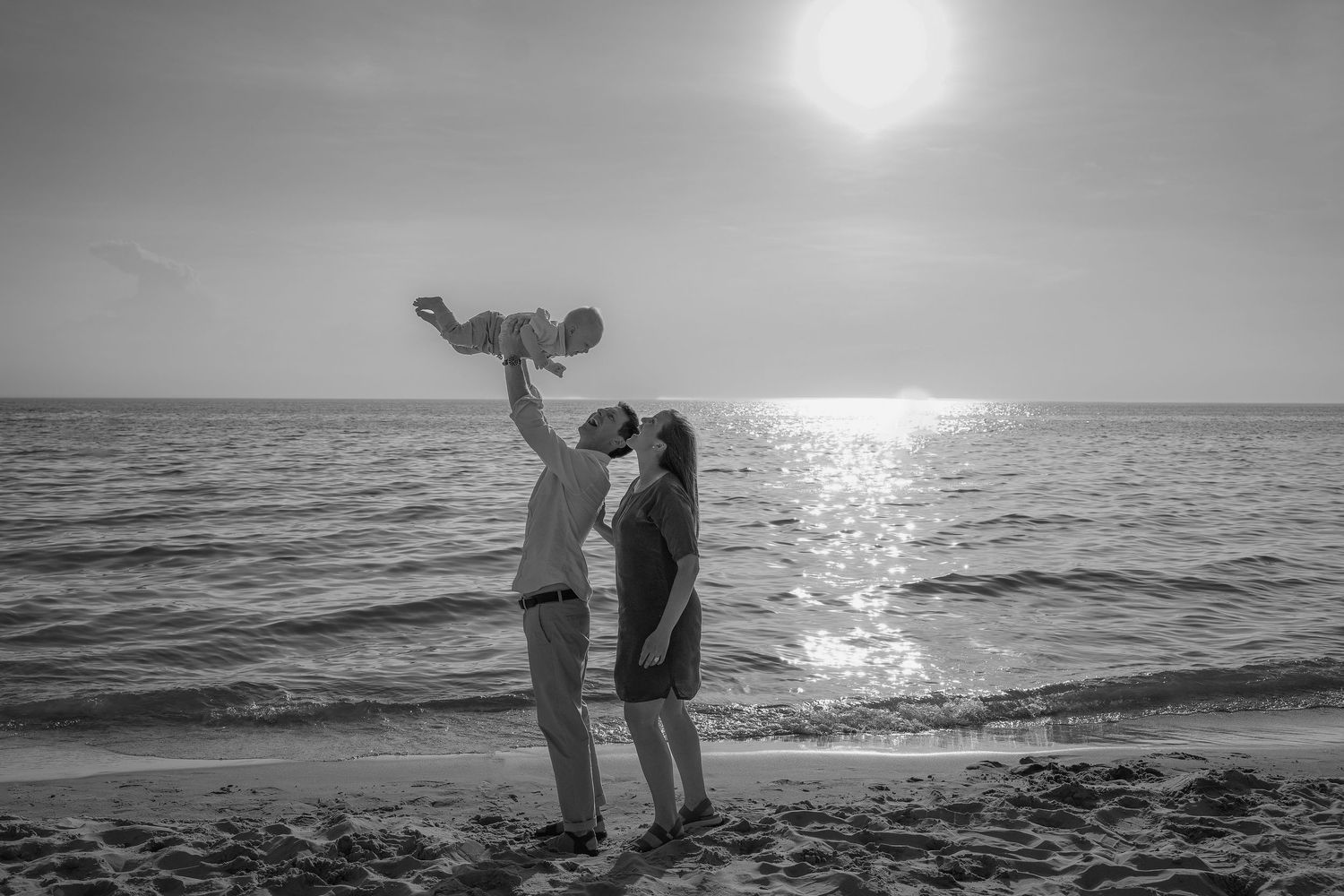 A black and white photo series shows silhouettes of a couple on a beach at sunset sharing romantic moments.