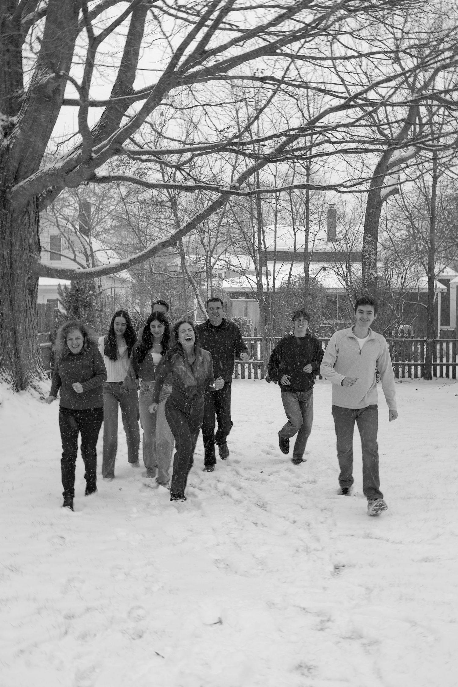 A sequence of black and white photos showing a group of people running through a snowy winter landscape.