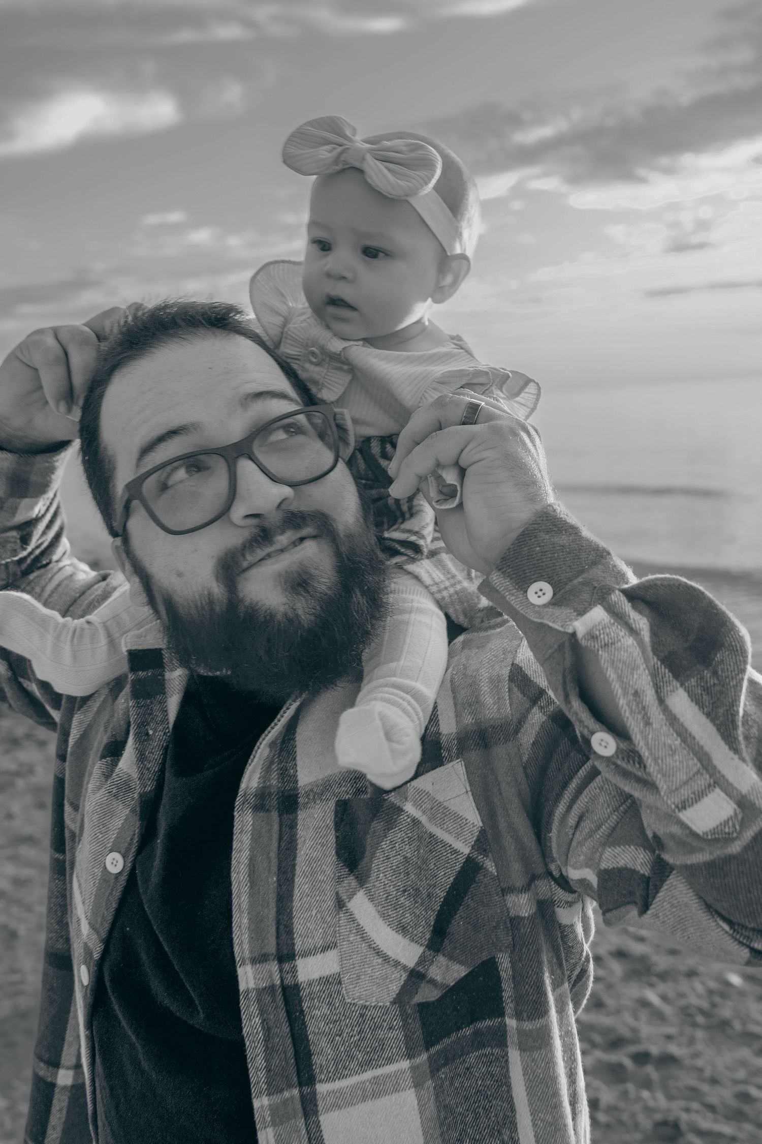 A series of black and white photos showing an adult and baby outdoors against a mountainous landscape.