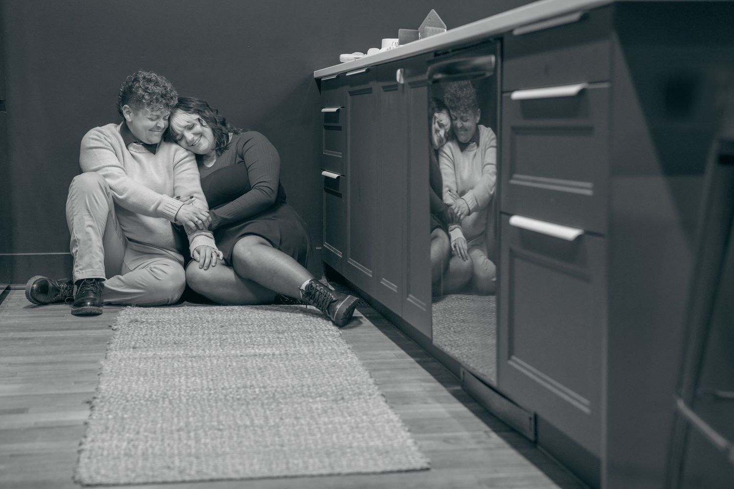 Black and white photo series showing intimate moments in a kitchen, with figures embracing and connecting over food preparation.
