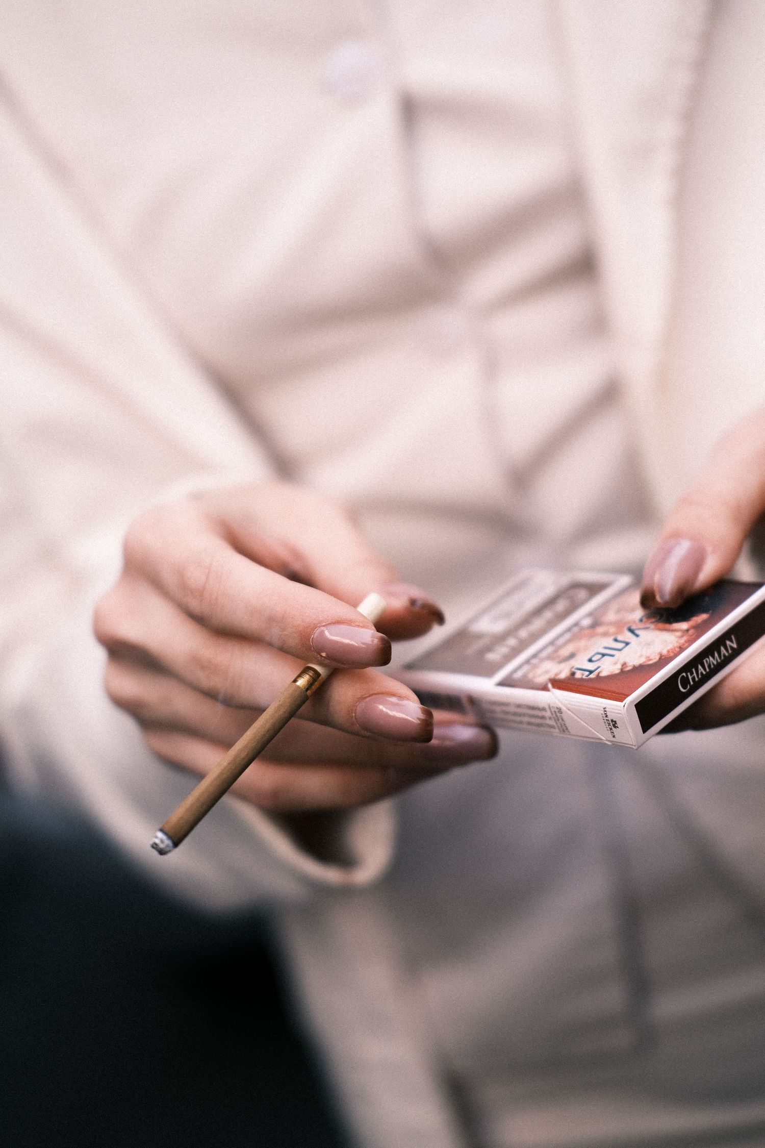 Hands rolling a cigarette with tobacco and paper shown in a sequence of close-up shots.