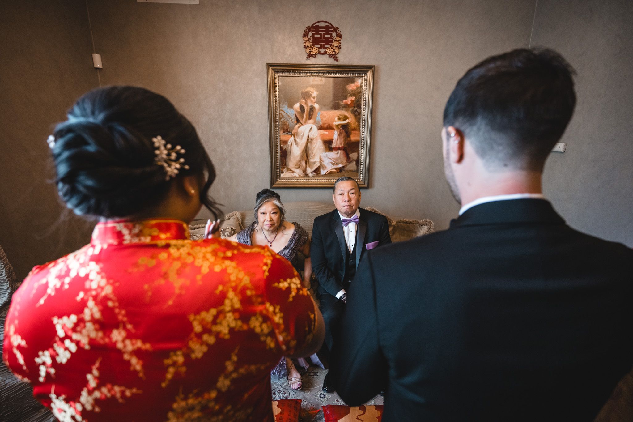 Traditional tea ceremony with guests in formal attire gathered in an elegant room.