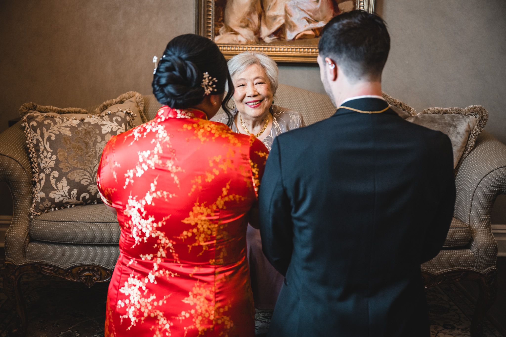 Traditional Chinese qipao dress in red silk with delicate floral patterns being worn during wedding preparations.