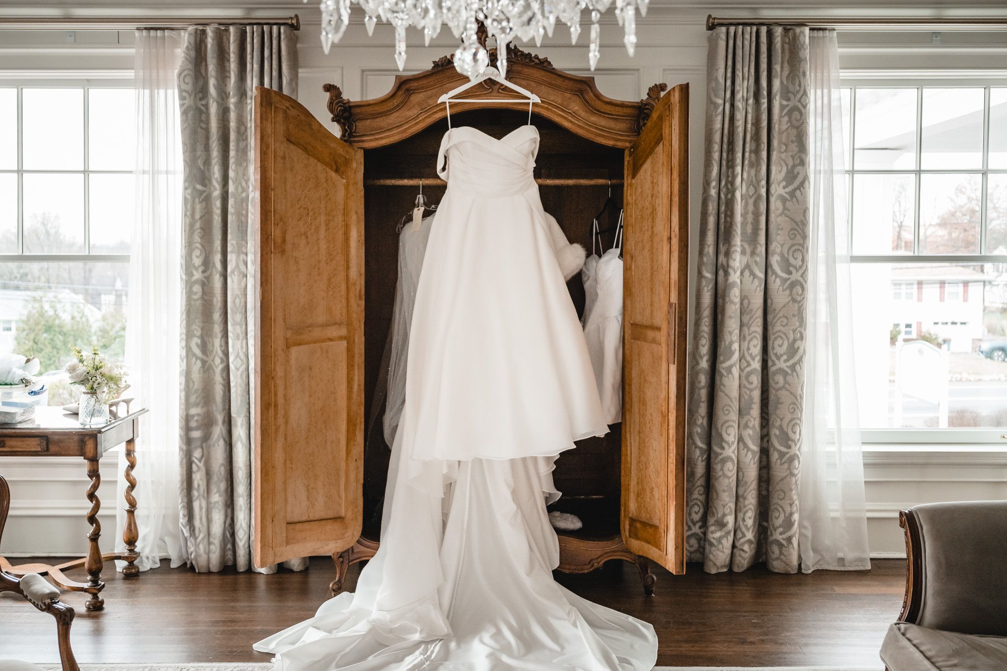 Elegant wedding venue interior with crystal chandelier and large windows letting in natural light.