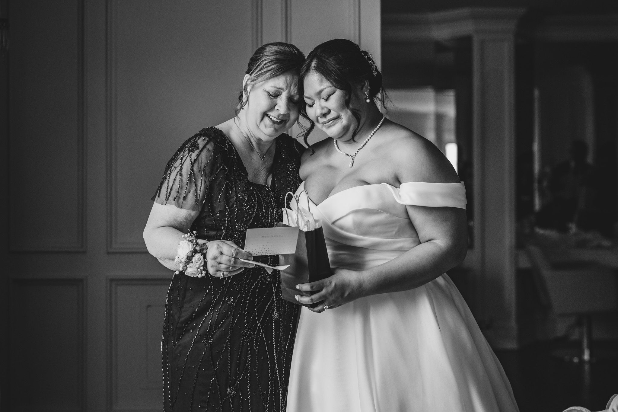 A touching black and white moment shared over drinks during wedding preparations.