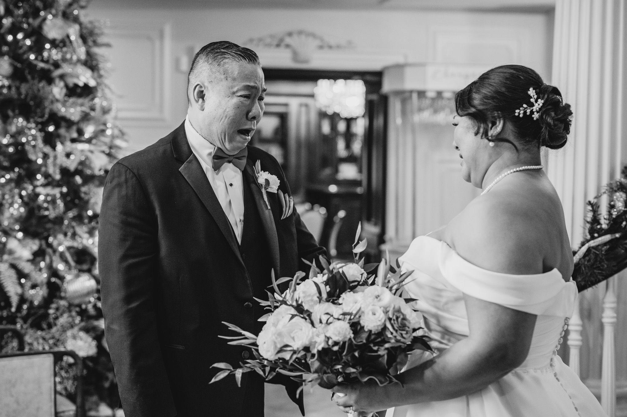 A candid black and white moment of joy and surprise during the first look at a wedding.