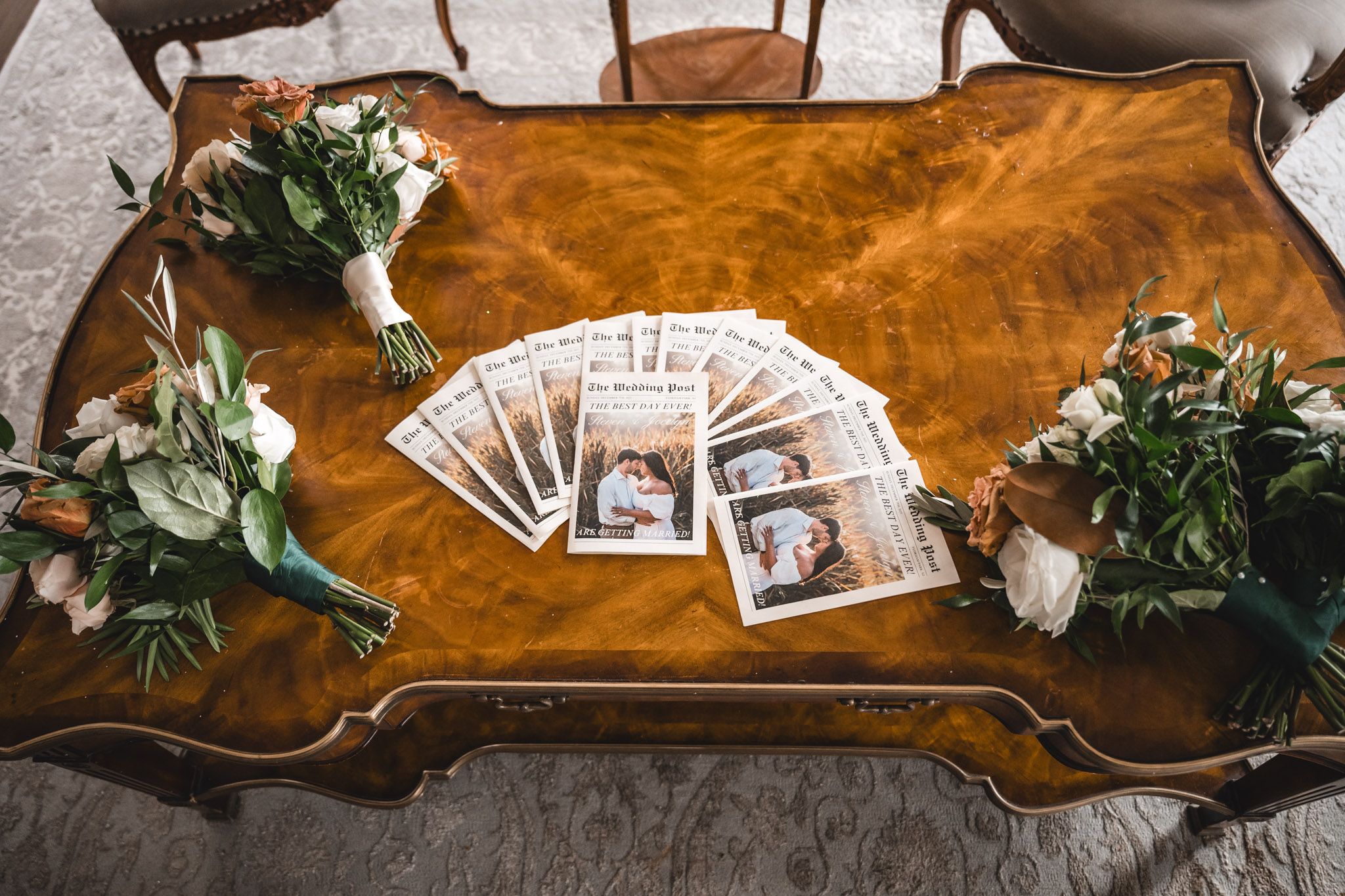 Wedding memorabilia and photographs arranged on polished wooden surface.