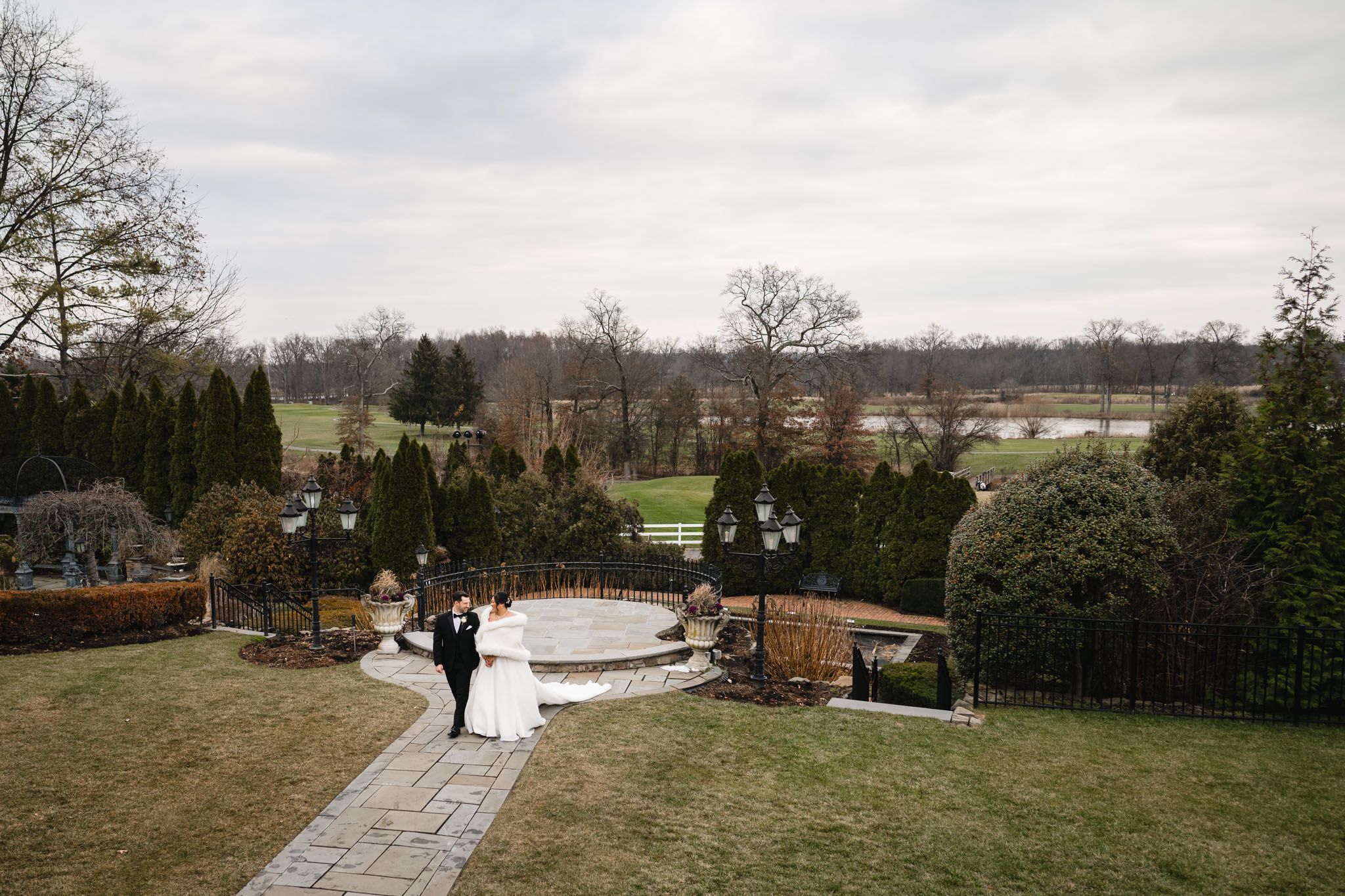 A wide landscape shot of a winter wedding ceremony with scenic views and stone pathways.