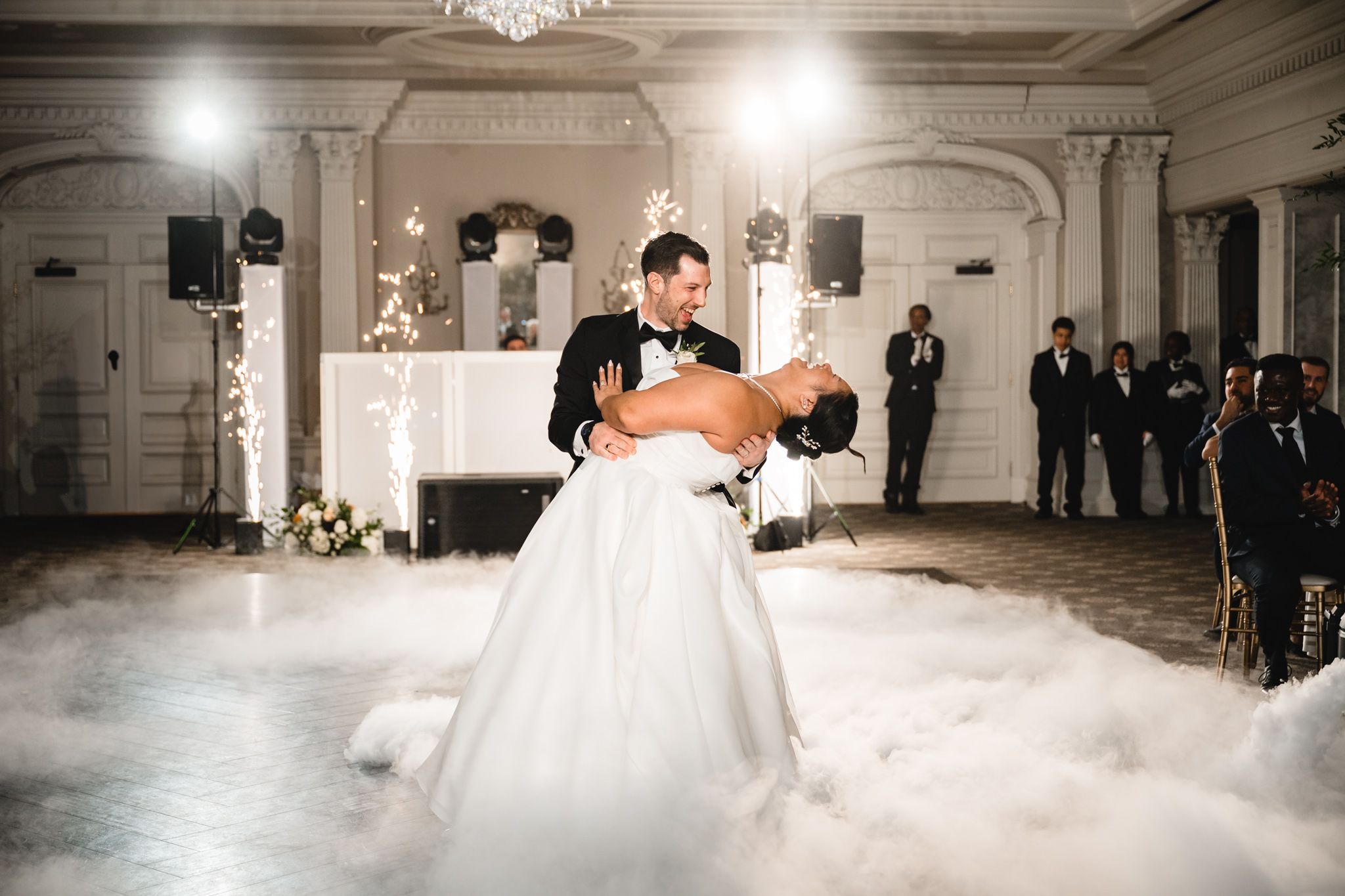 Romantic dance moment captured in sepia tones with dramatic fog effect in classic ballroom setting.