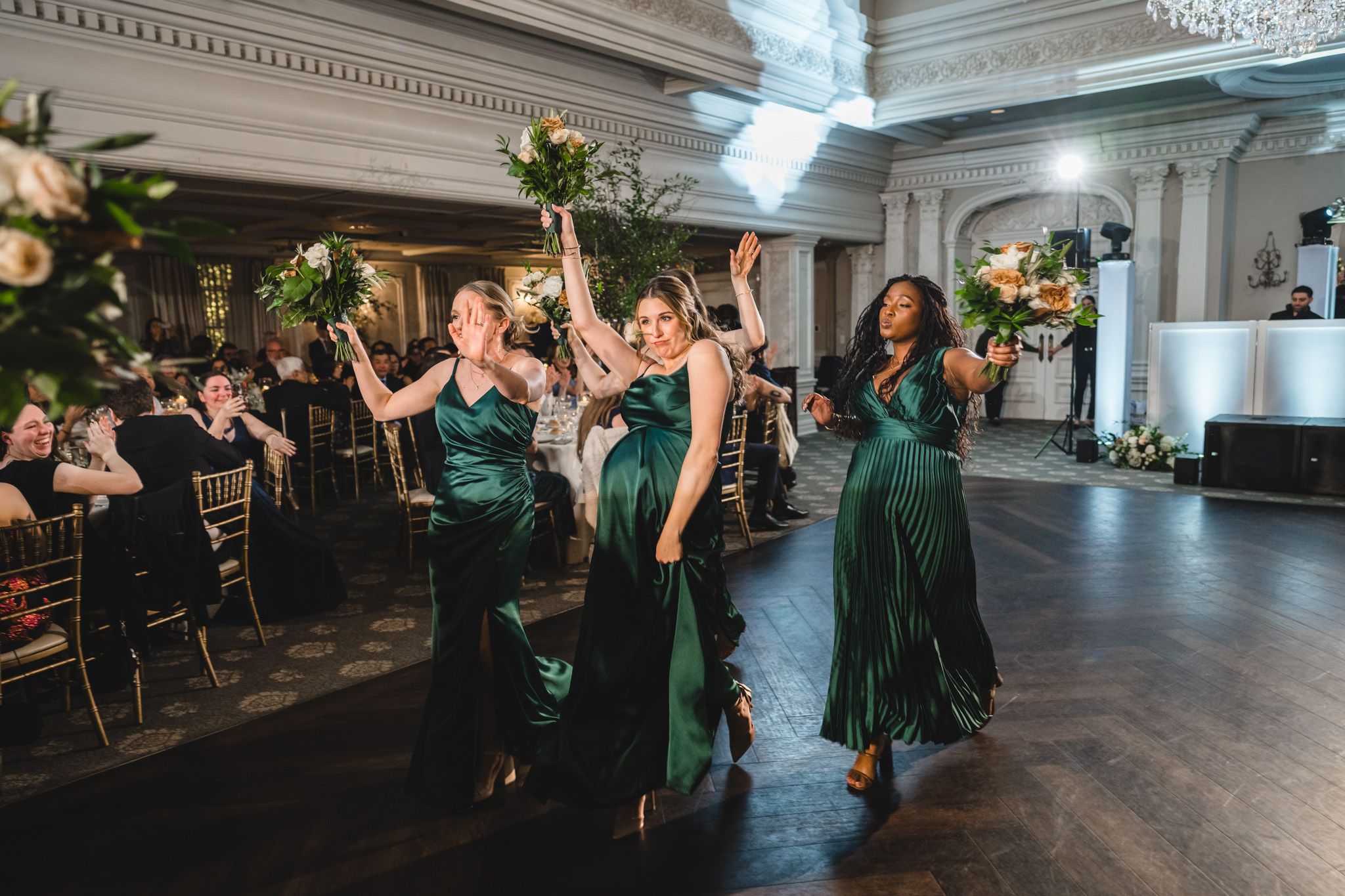 Elegant wedding reception with guests dancing in a spacious ballroom with classical architecture.