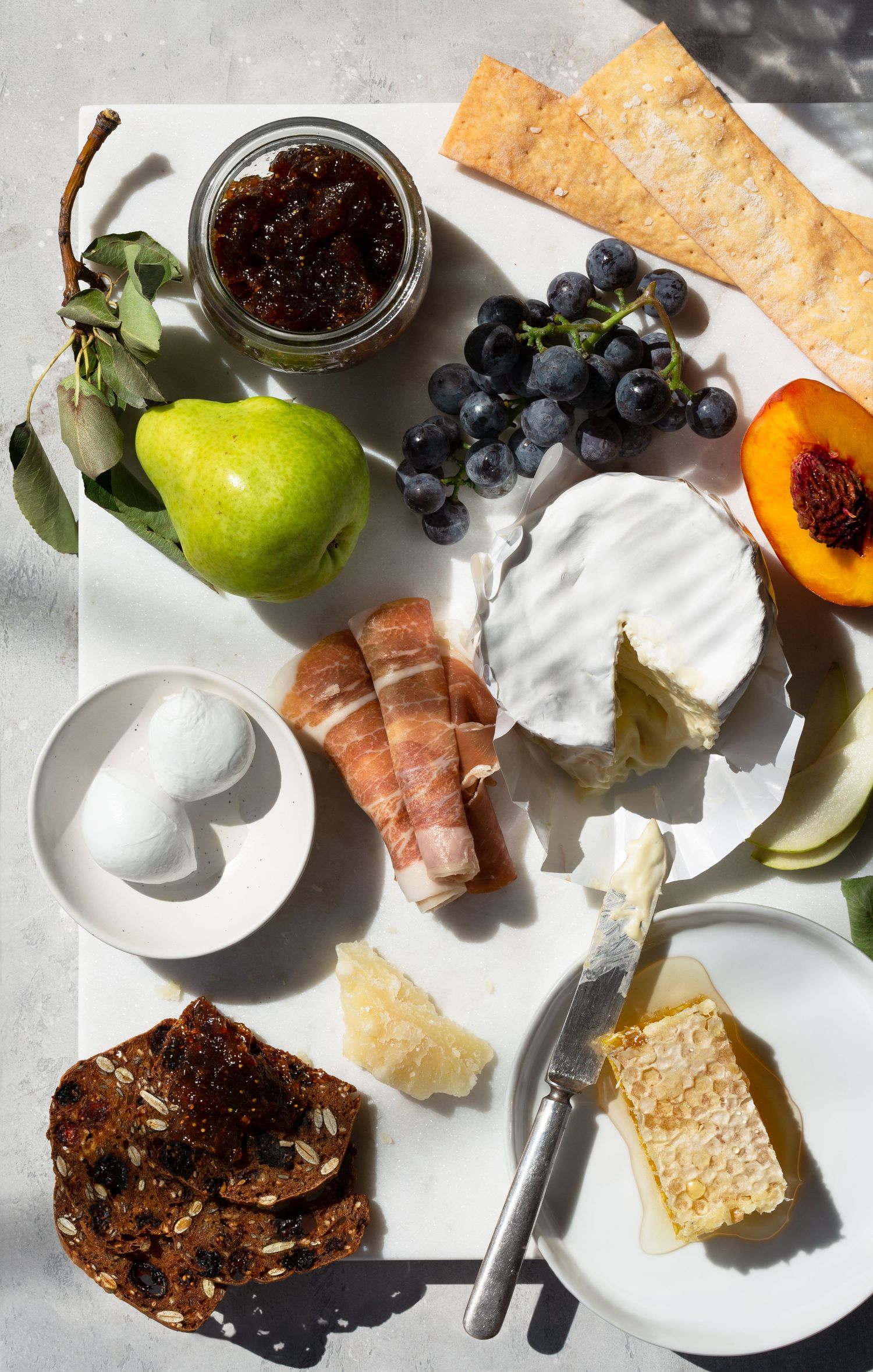 Charcuterie spread with meats, fruits and cheeses shot in bright, summery midday light