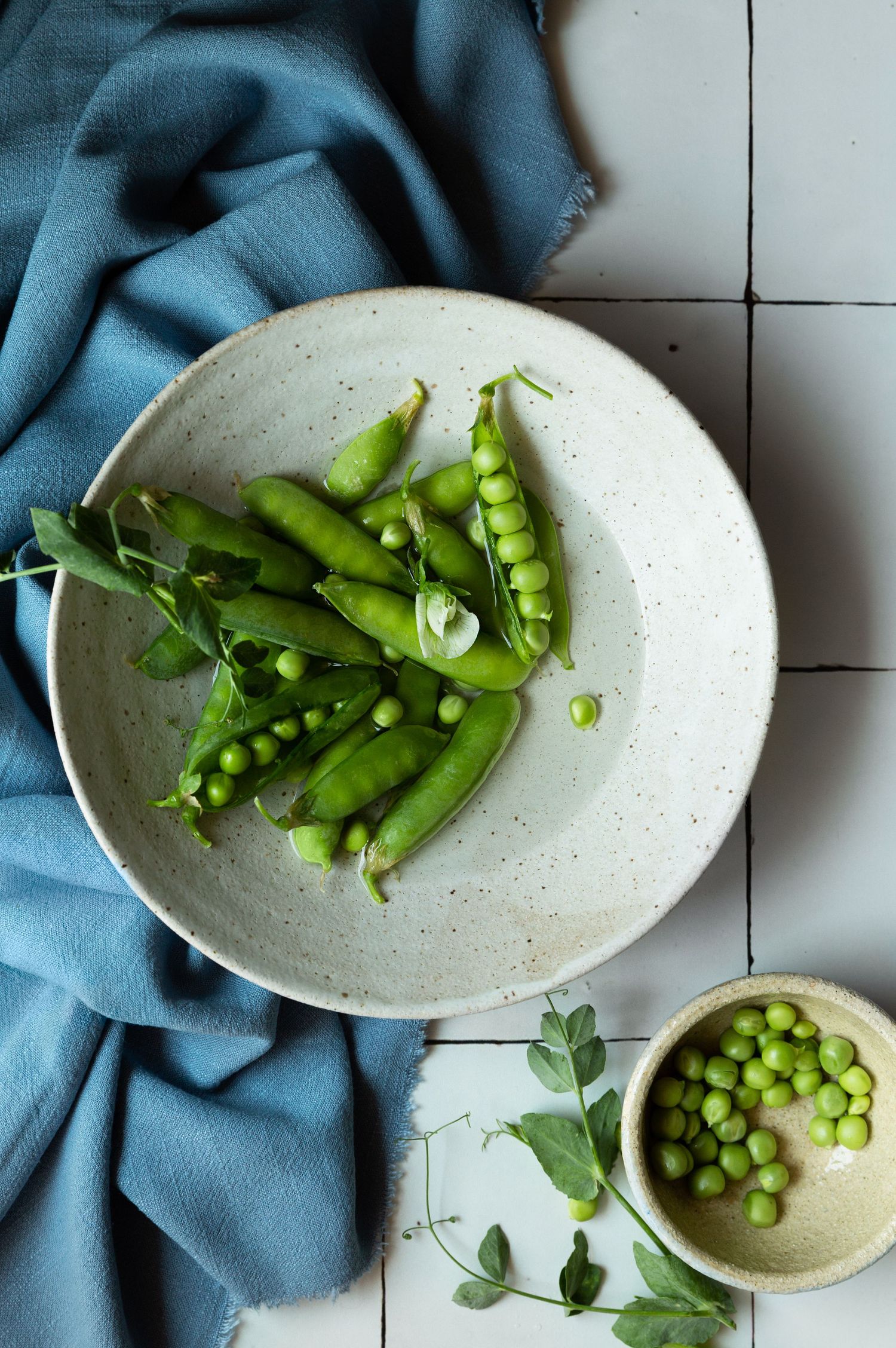 Sugar snap peas styled against a tiled backdrop