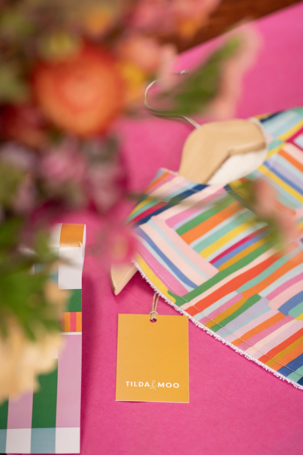 Colorful striped design materials and branding elements laid out on a pink surface.