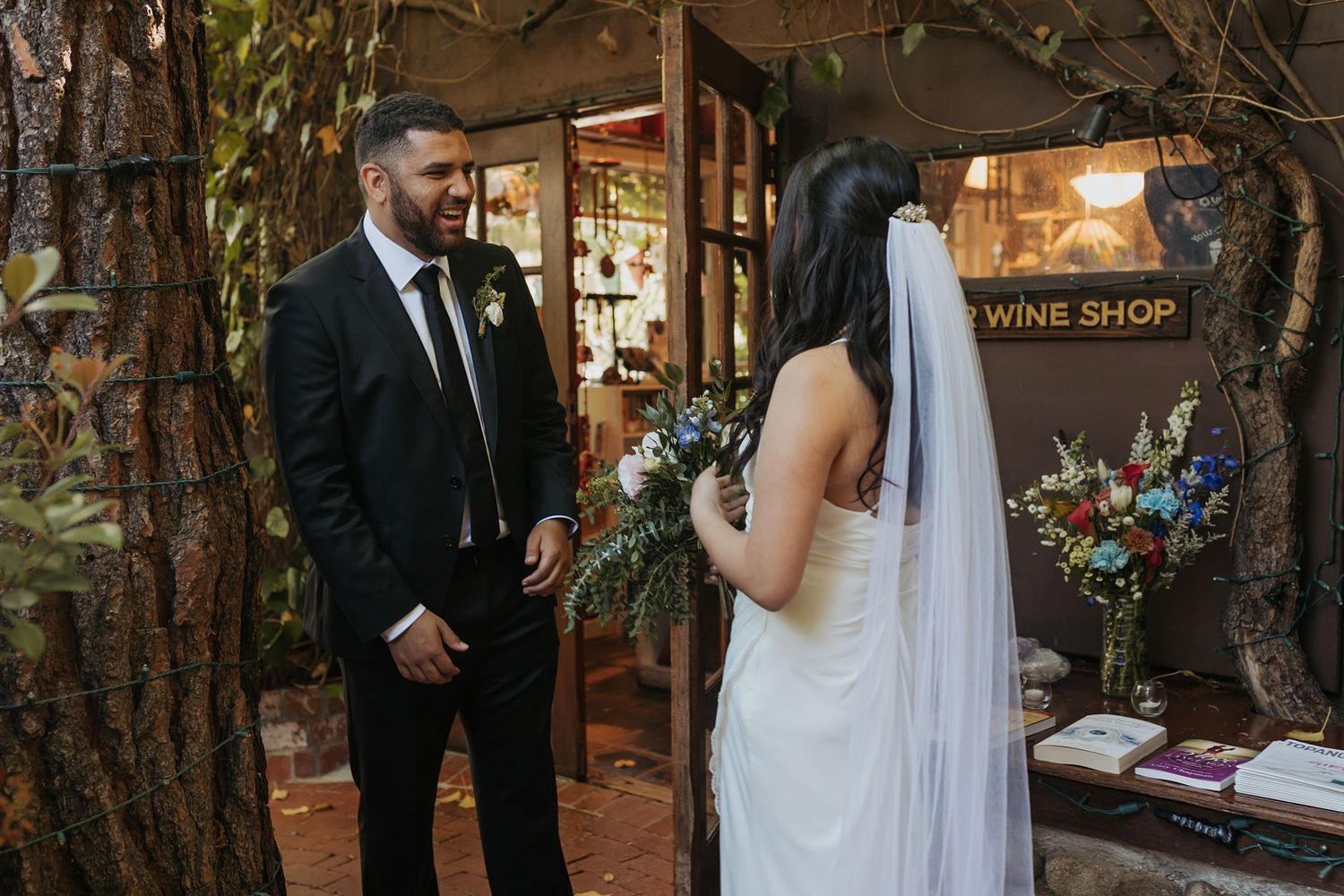 Newlyweds share an intimate first look moment in a rustic garden setting during their wedding celebration.