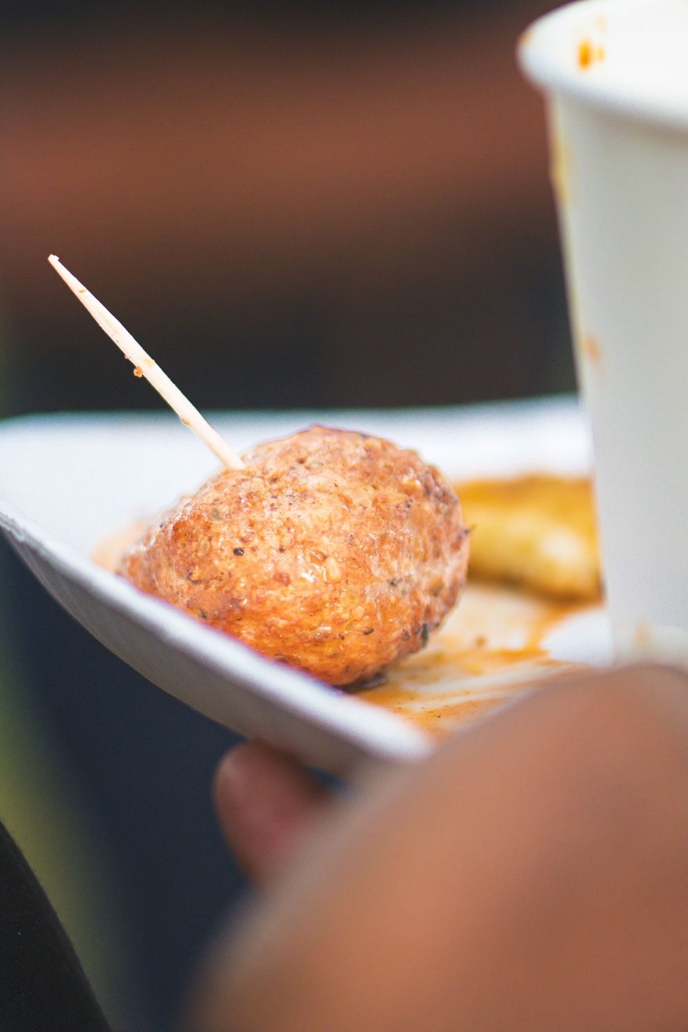 A close-up sequence of someone eating a piece of crispy breaded food with chopsticks.