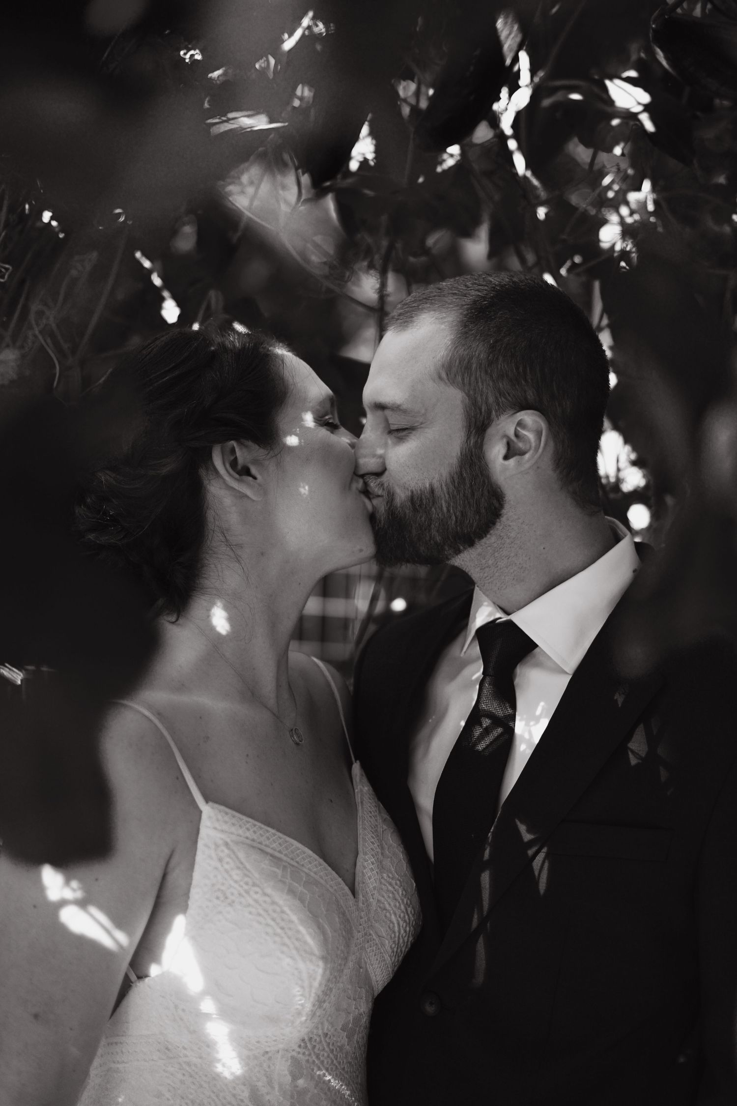 Artistic black and white photo of a tender romantic moment at a wedding.