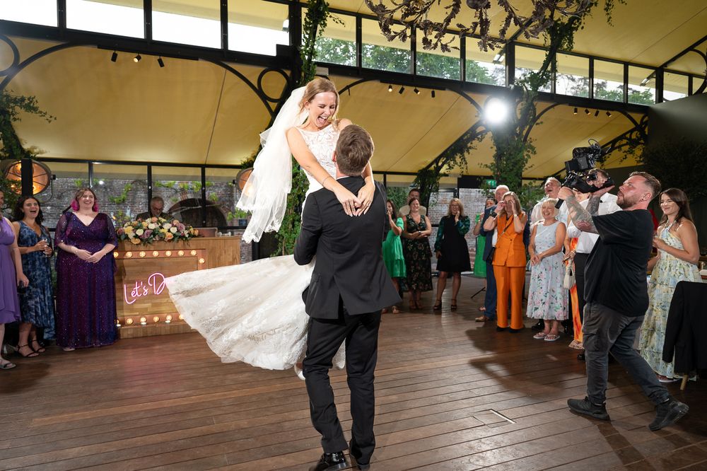 A bride and groom twirl and enjoy their first dance at their reception in The Orangery at Port Lympne Reserve.