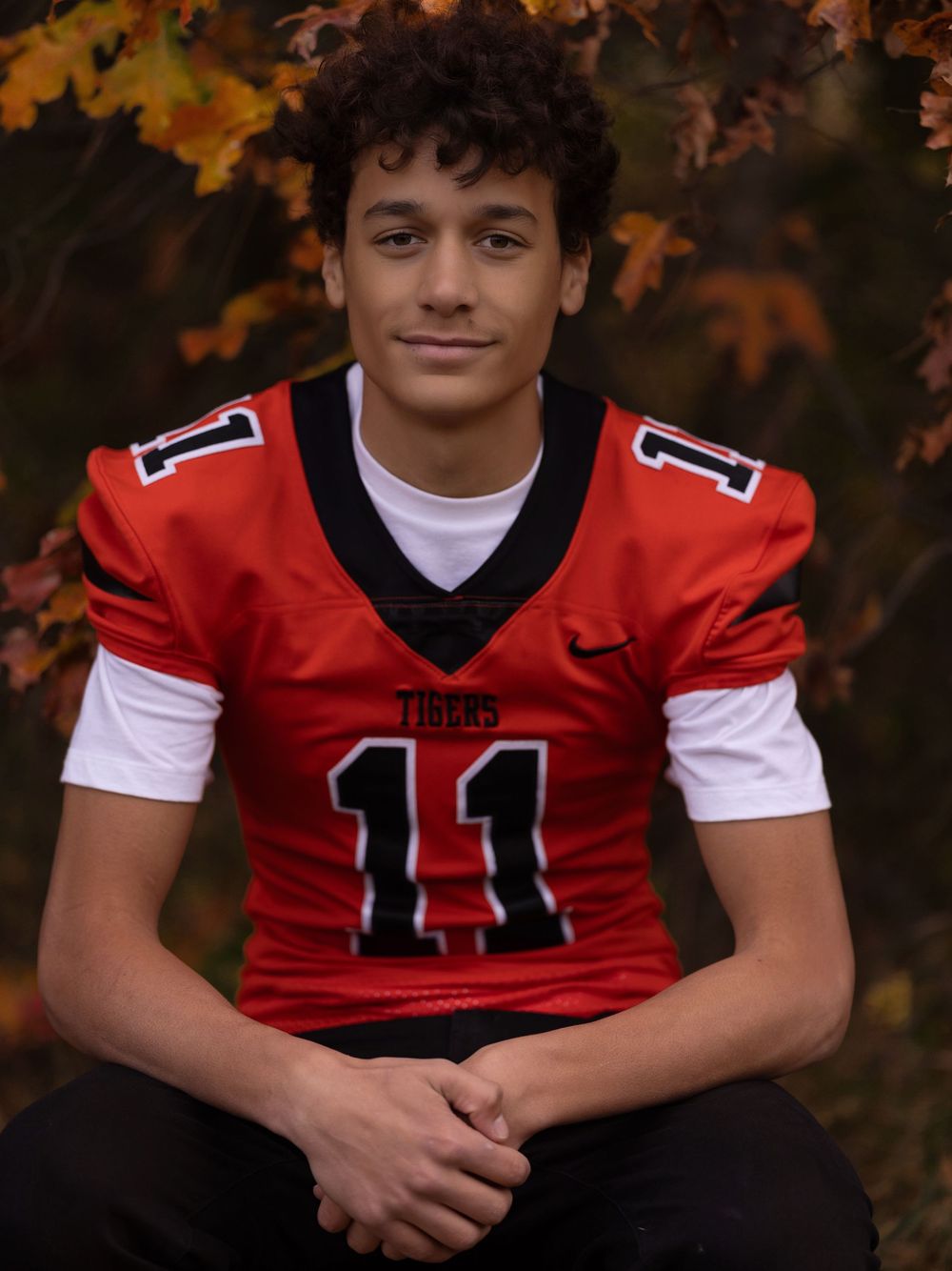 Athletic portraits featuring a red and white football jersey number 11 against autumn foliage.