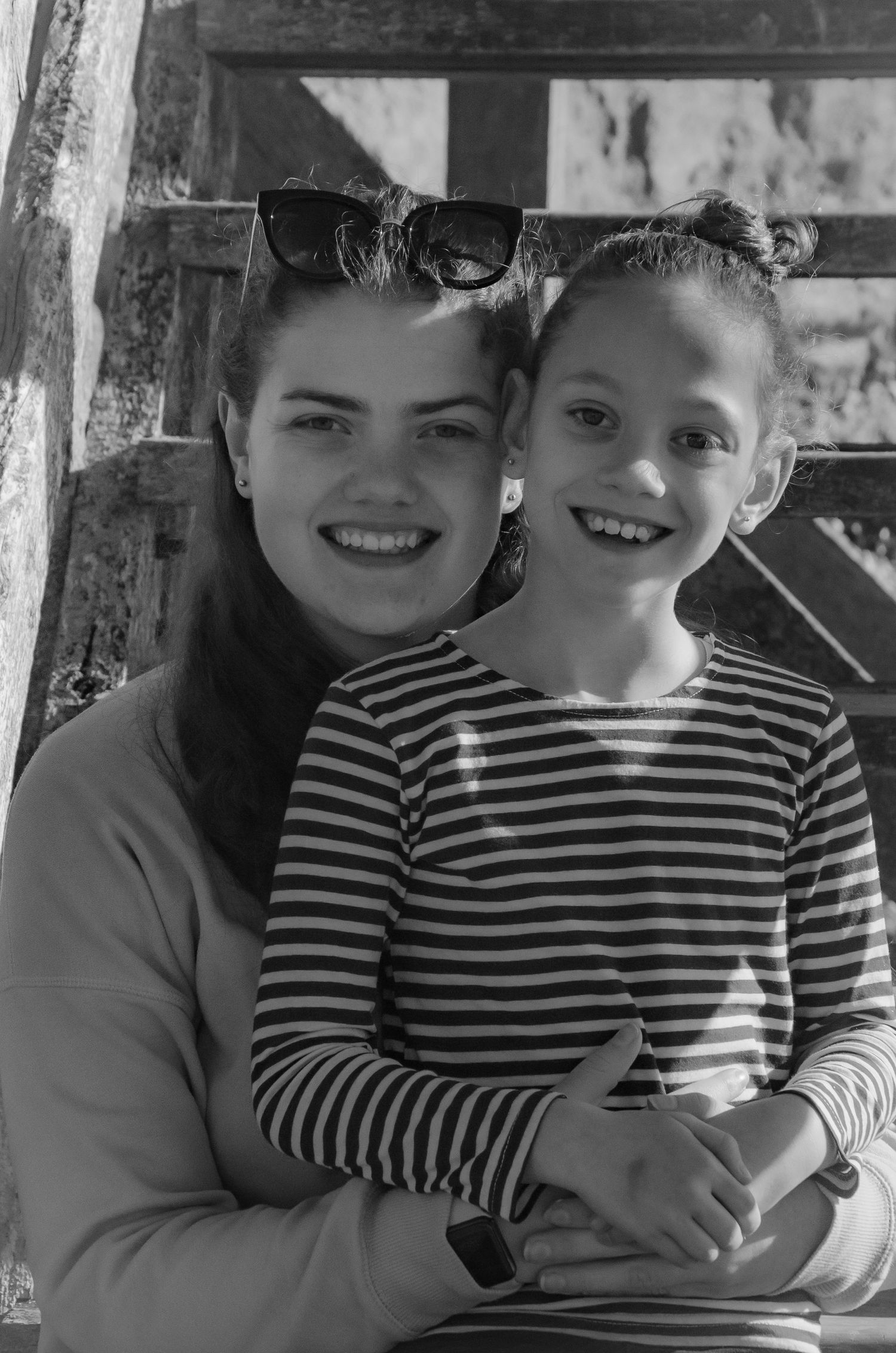 Black and white portrait of two people smiling together in casual stripes.