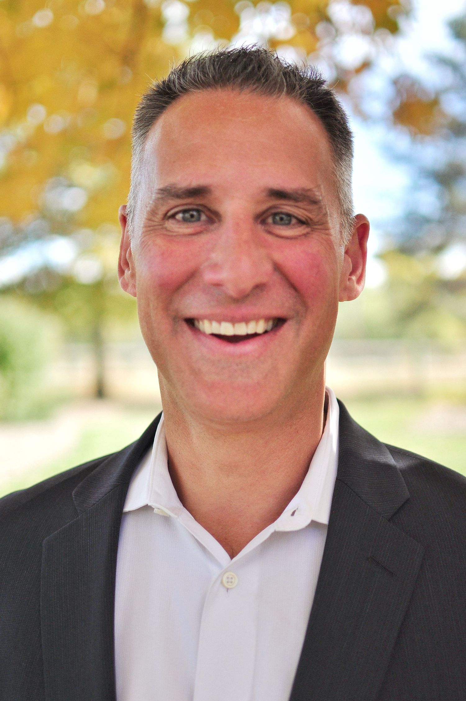 Man's headshot with yellow leaves in the background