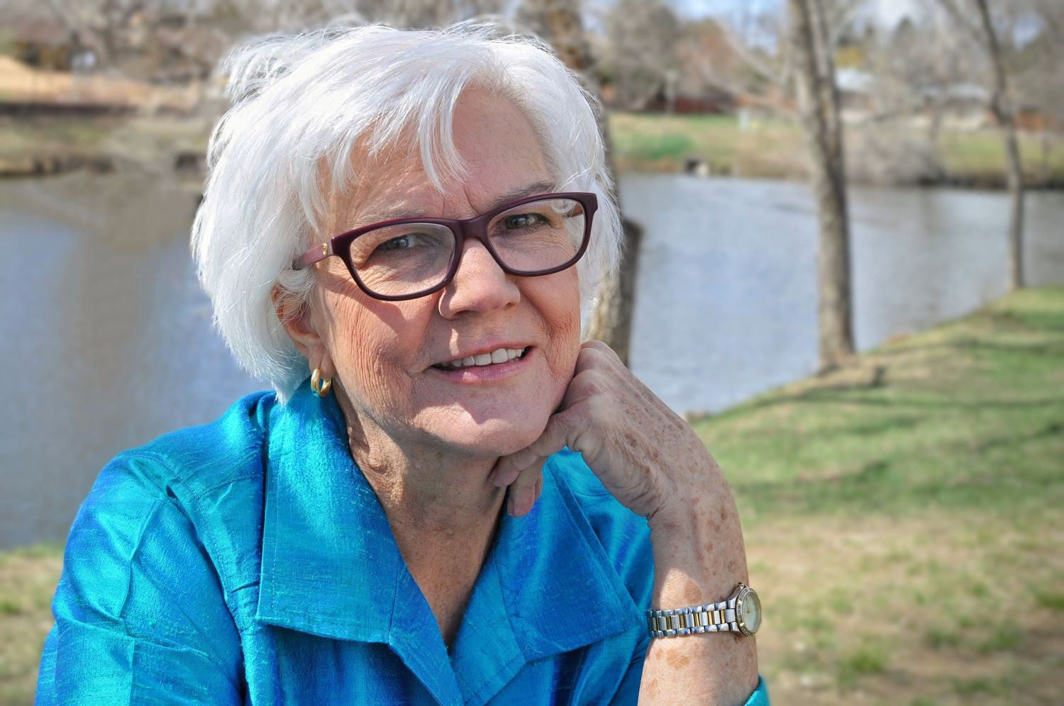 Lady with glasses rests her hand on her cheek