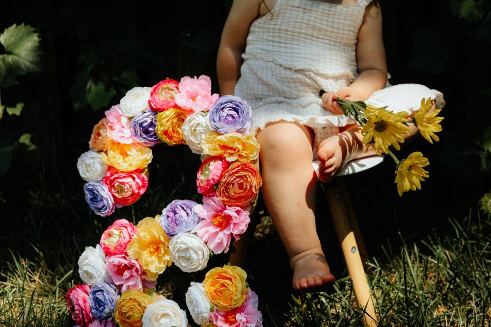 Colorful artificial flowers arranged in a decorative display on grass.