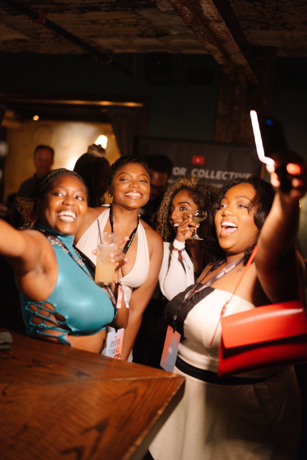 A group of party-goers smile and pose together during a fun night out at what appears to be a bar or club.