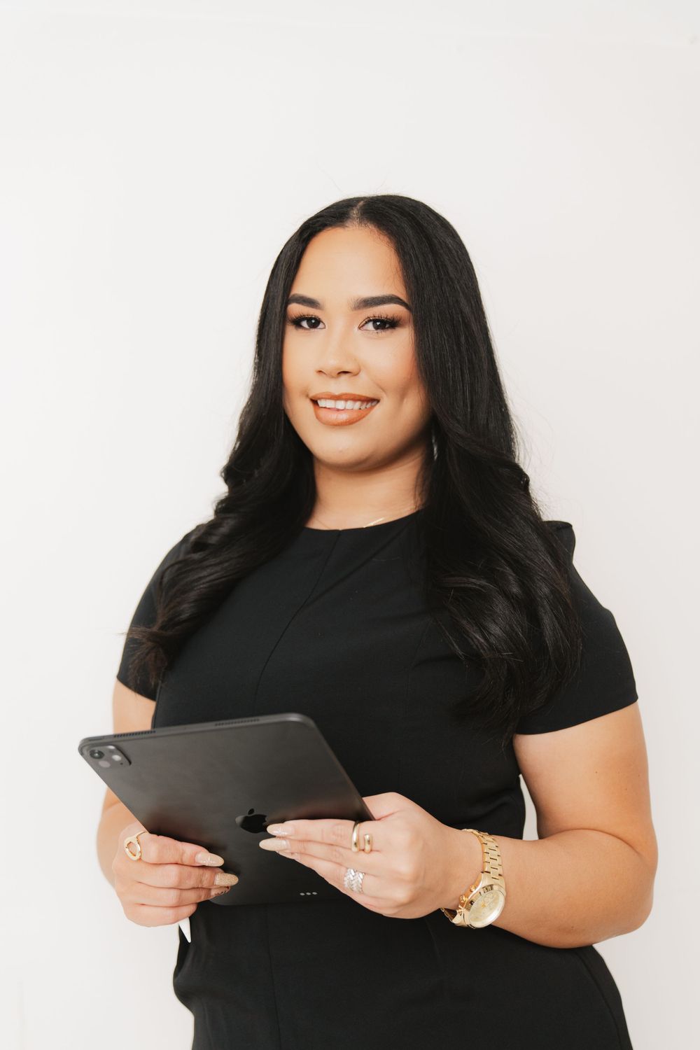 Professional woman in black top holding tablet device against white background.