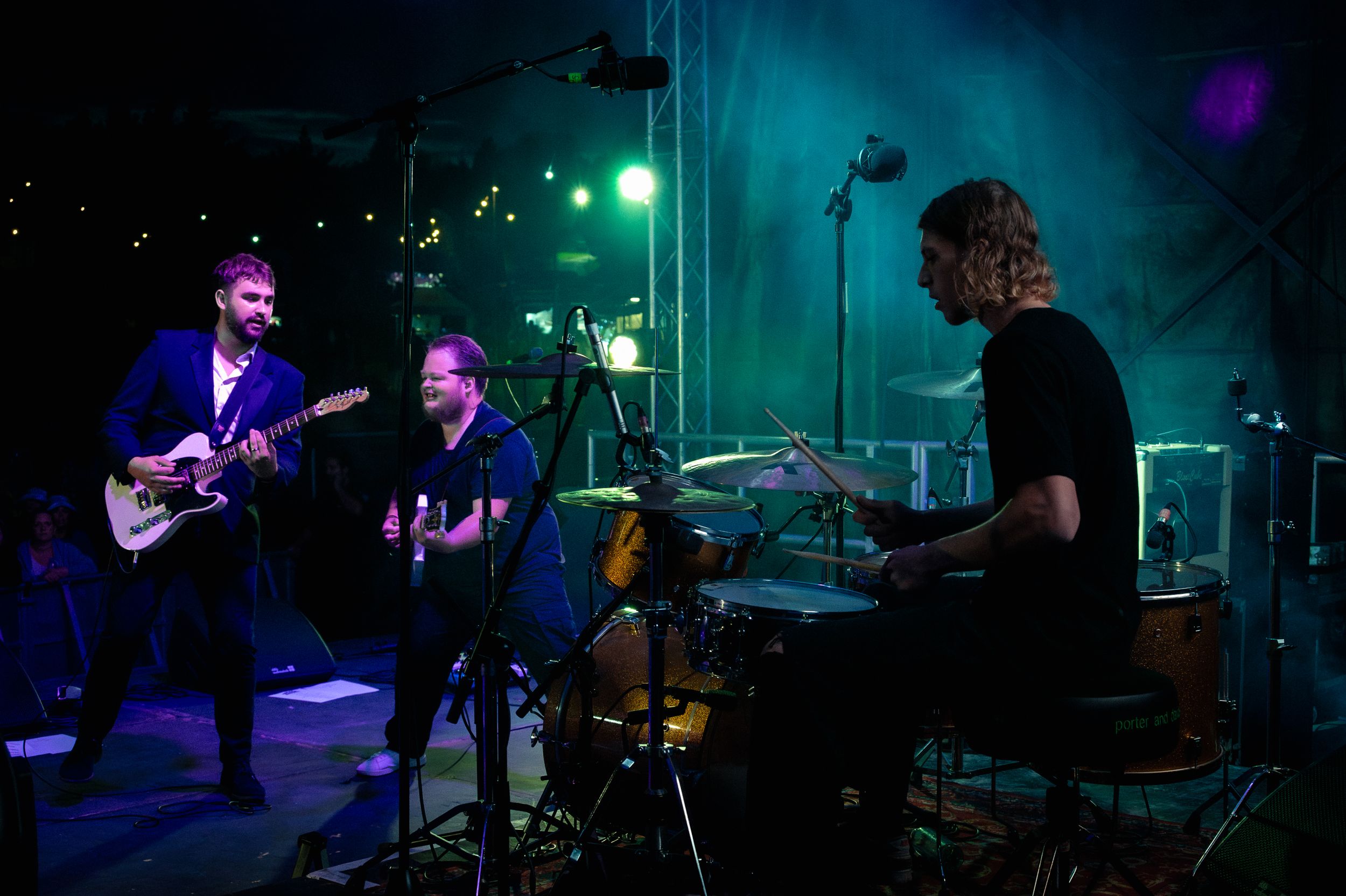 Musicians performing on darkened stage with blue atmospheric lighting.