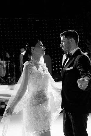 Black and white photo of bride and groom sharing an intimate first dance at their elegant wedding reception.