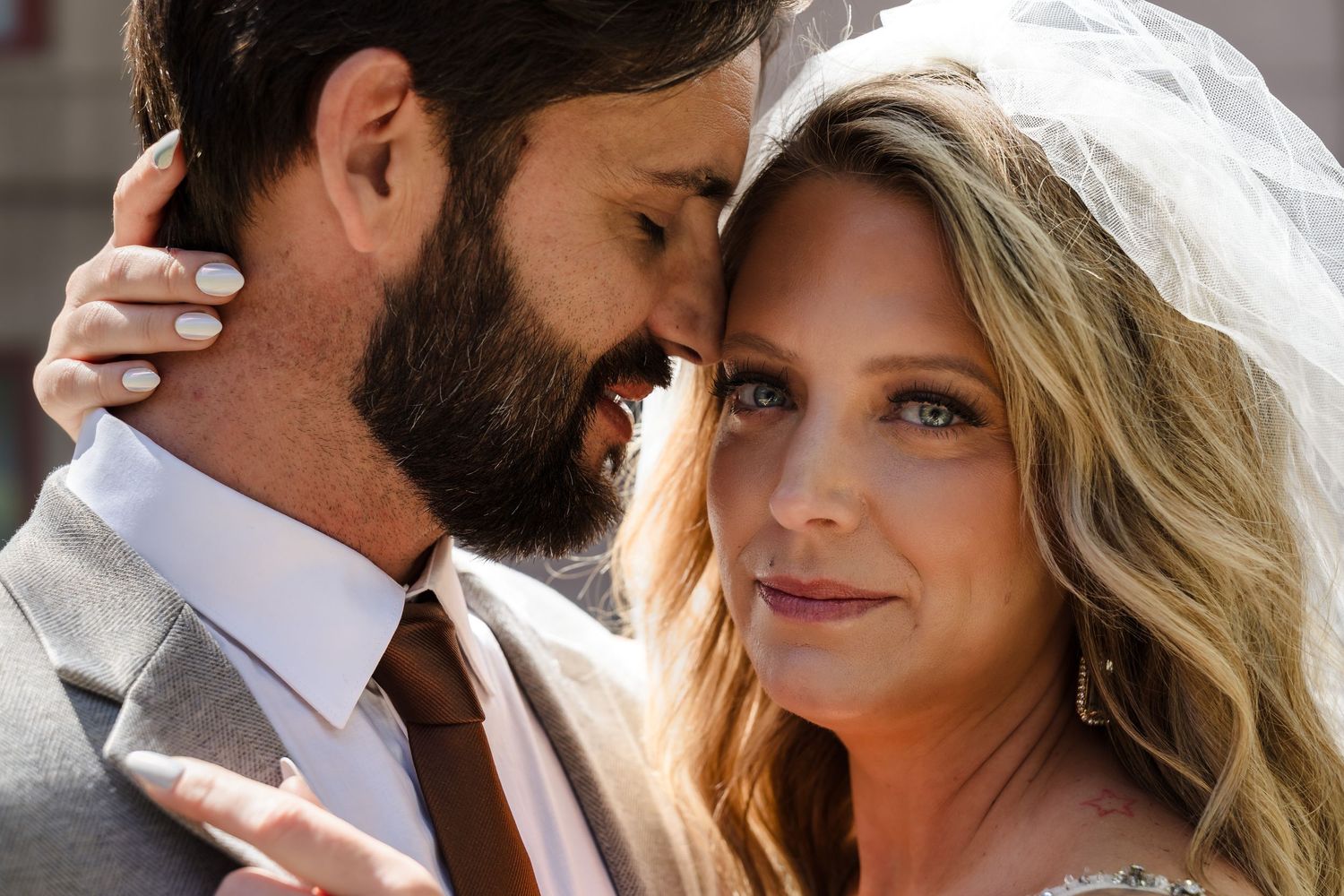 Intimate close-up wedding portrait of a bride and groom, showcasing refined and natural tones in a quiet moment.