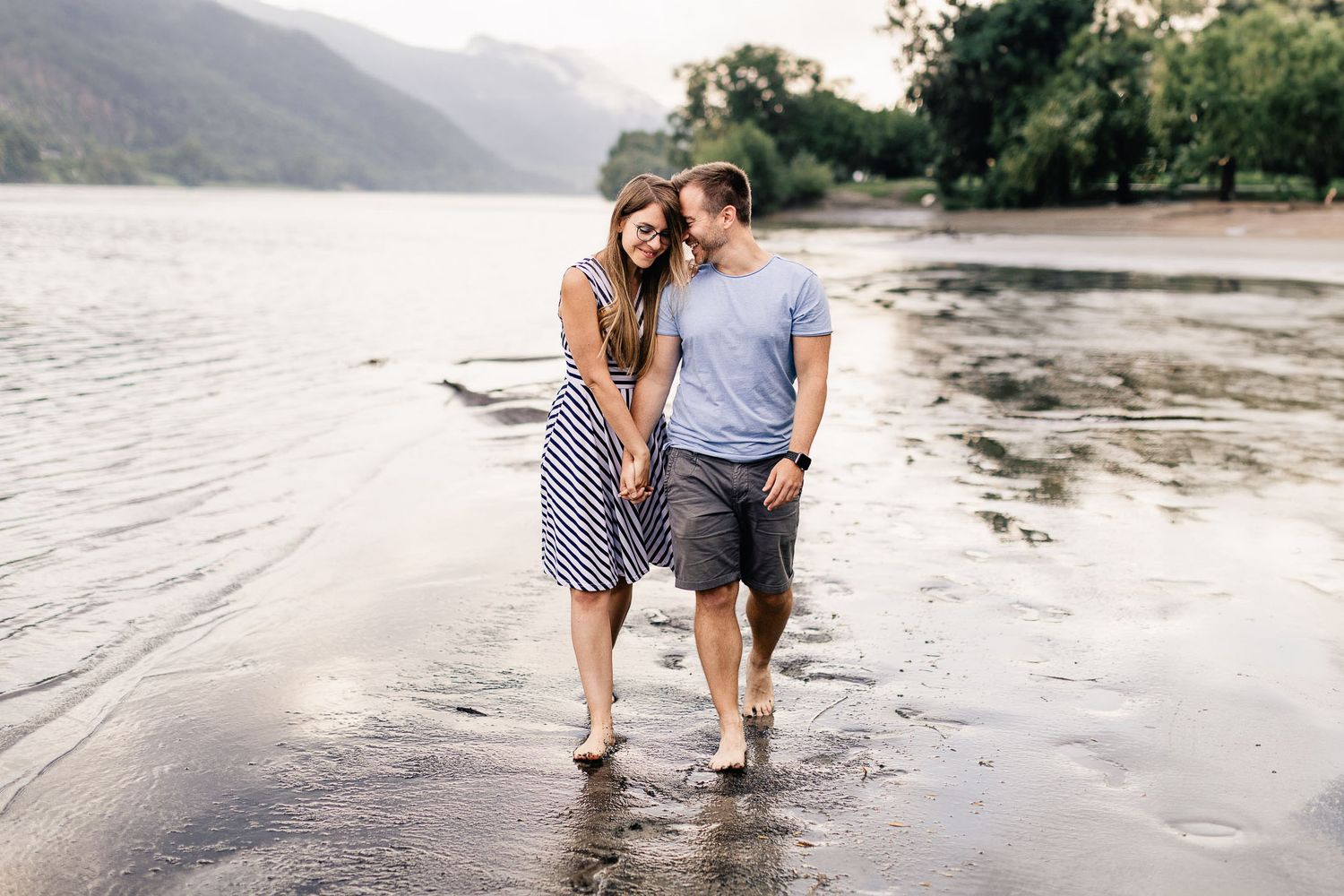 Eine vierköpfige Familie sitzt während eines Fotoshootings im Freien an einem freundlichen Tag auf einer Wiese zusammen.