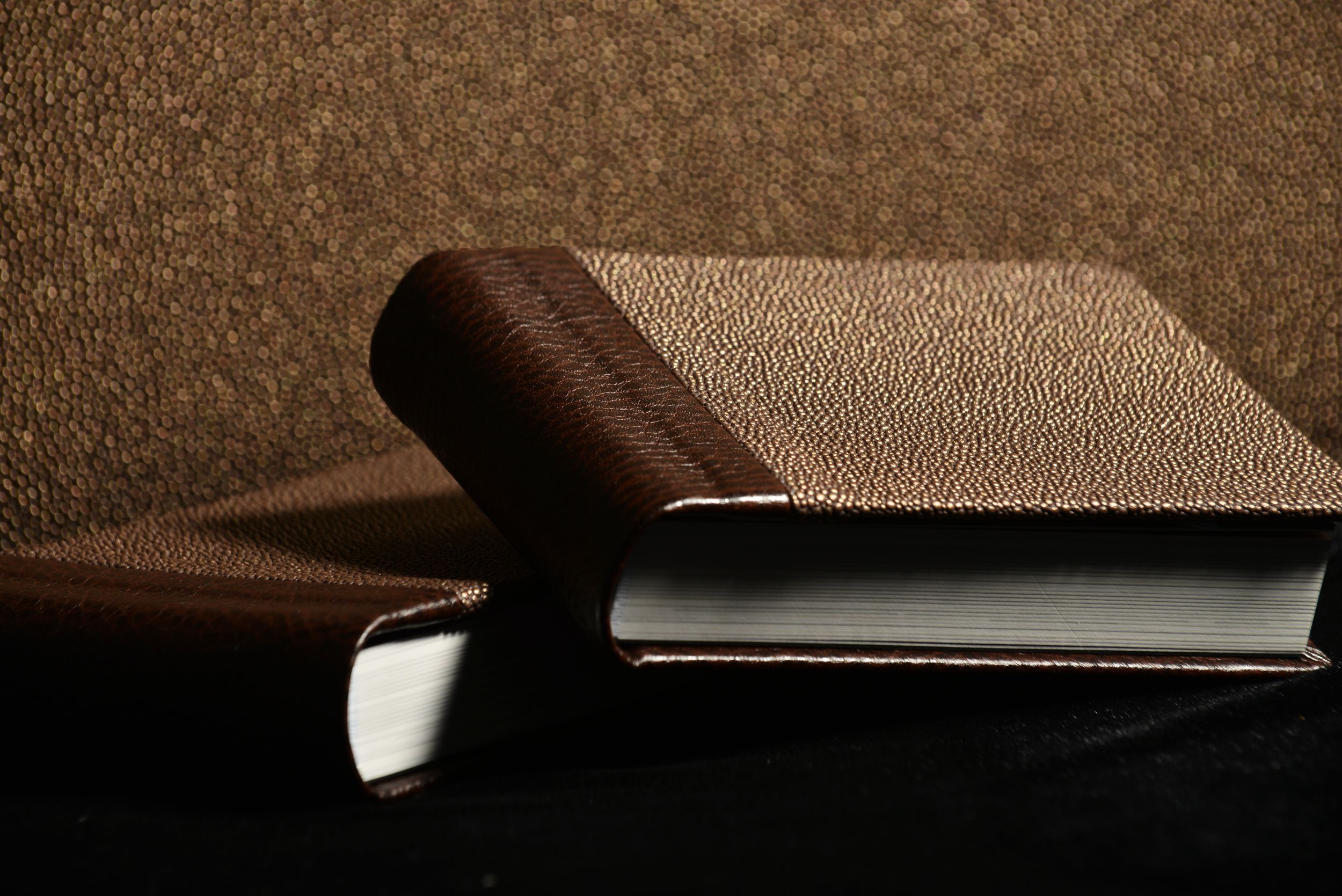 Close-up of a brown leather wallet or billfold partially open on dark surface showing textured material detail.