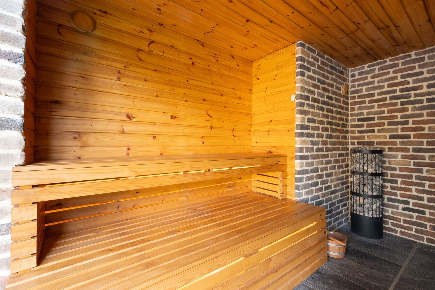 Wooden sauna interior in Bedfordshire with tiered benches and stove, photographed for spa photography.