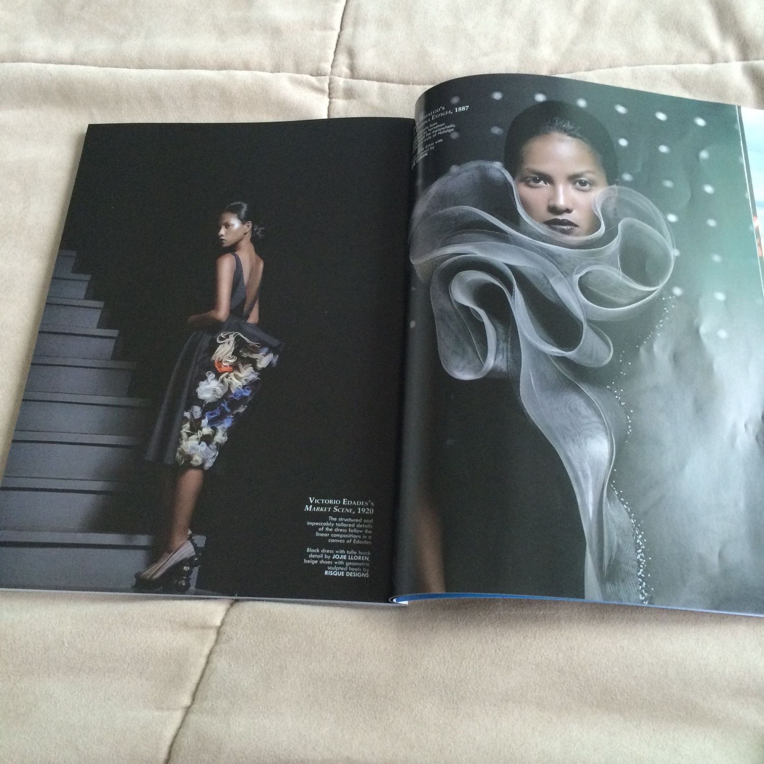 Open fashion magazine displaying two editorial photos of models, one in floral dress on stairs, other with sculptural gray design.