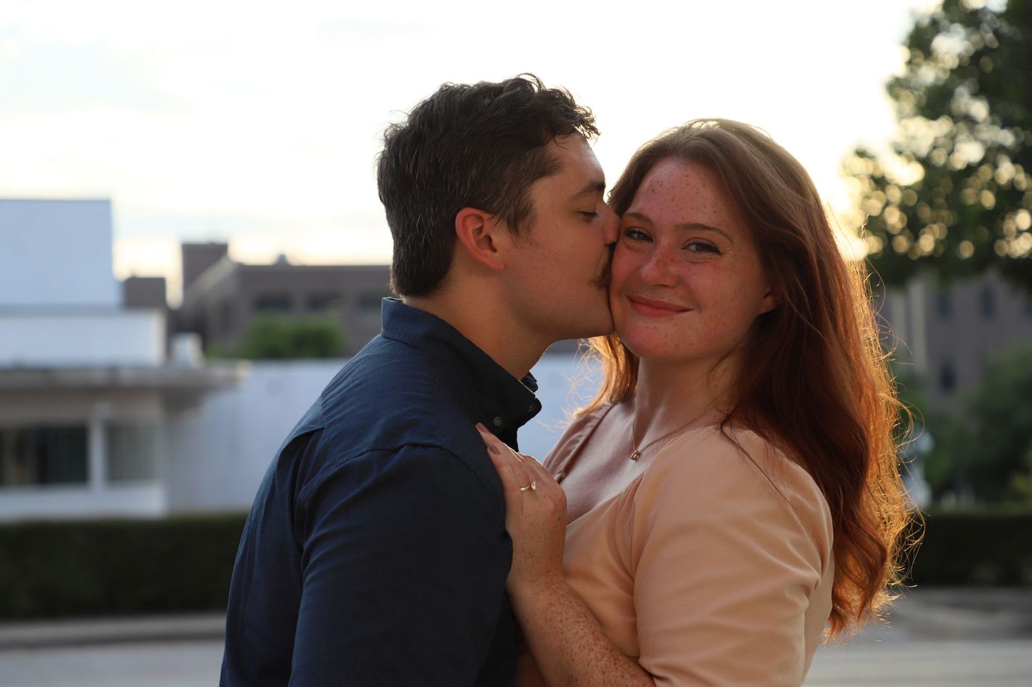 Man kissing his fiancée on the cheek during an engagement session