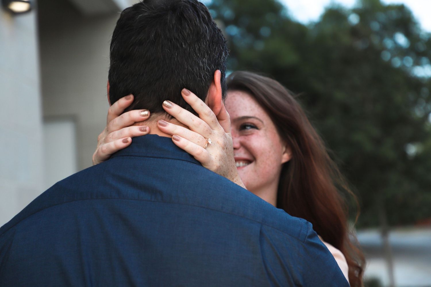 Woman smiling at her fiancé while displaying her engagement ring