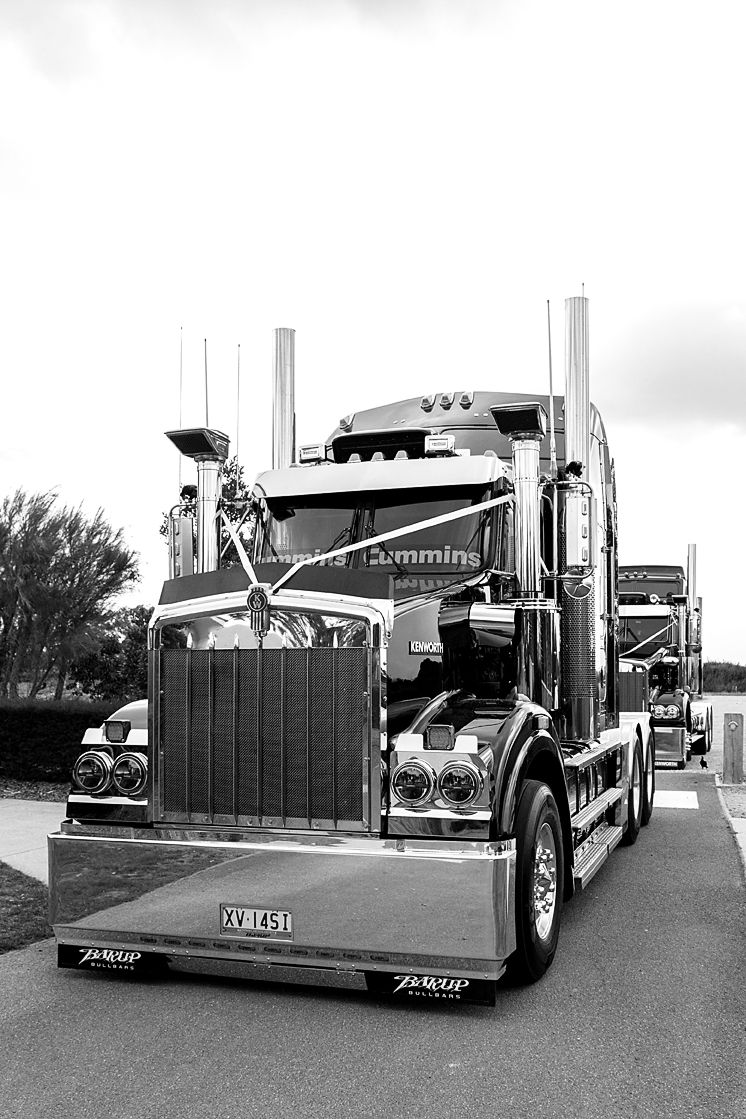 Four black and white photographs of custom semi trucks with sleek, aerodynamic designs parked in a line.