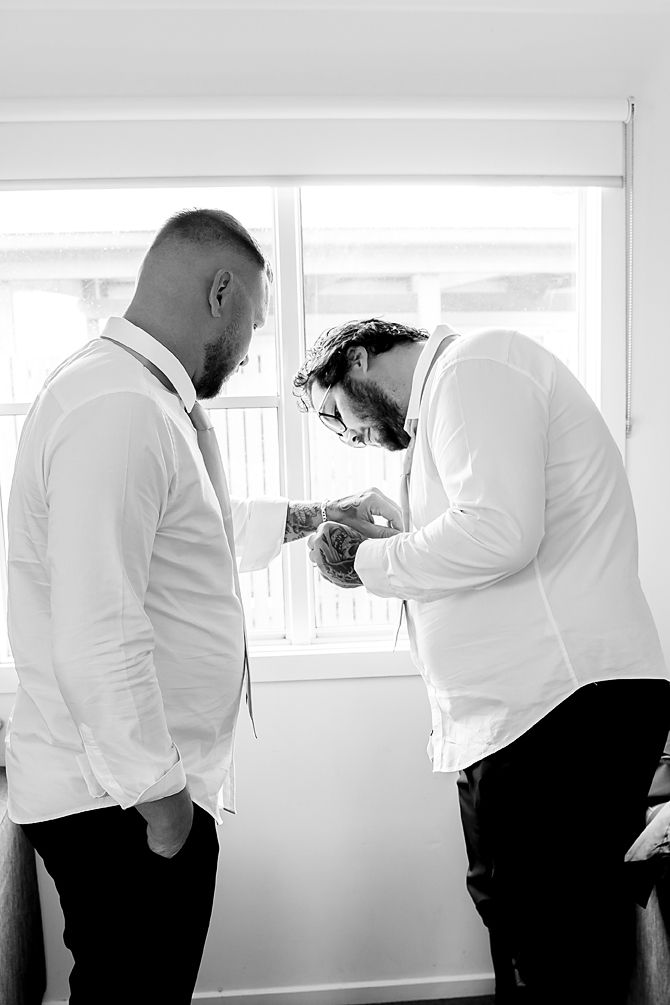A series of black and white photos showing two people in white shirts embracing in front of a bright window.