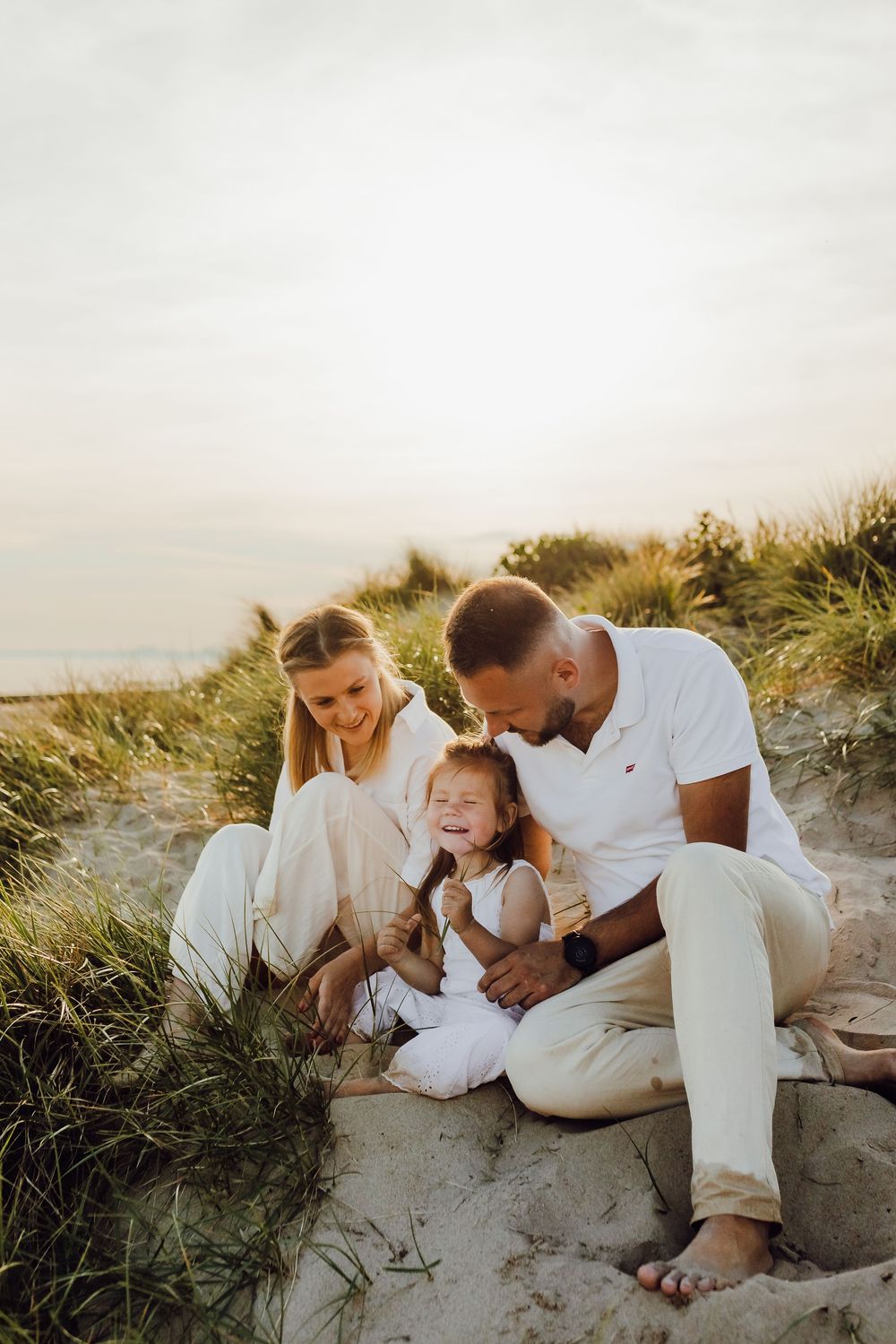 Parents and children playing together on Bournemouth beach, candid family photo session